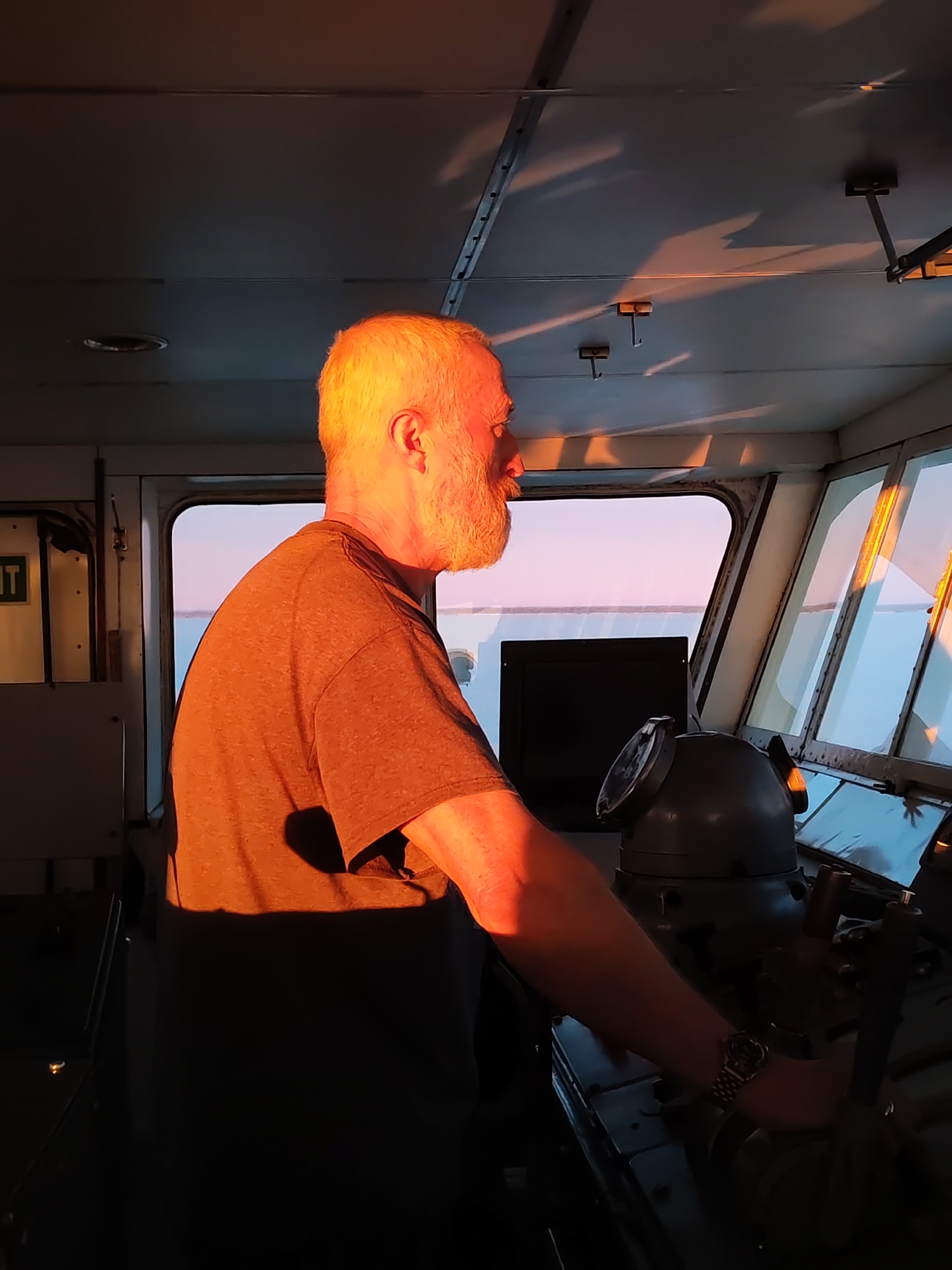 Ship captain navigates vessel near Bereg, Russia early morning