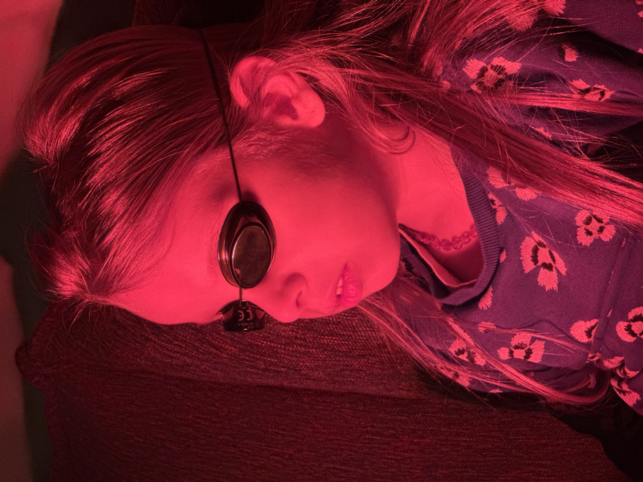 Girl receives red light therapy treatment at home