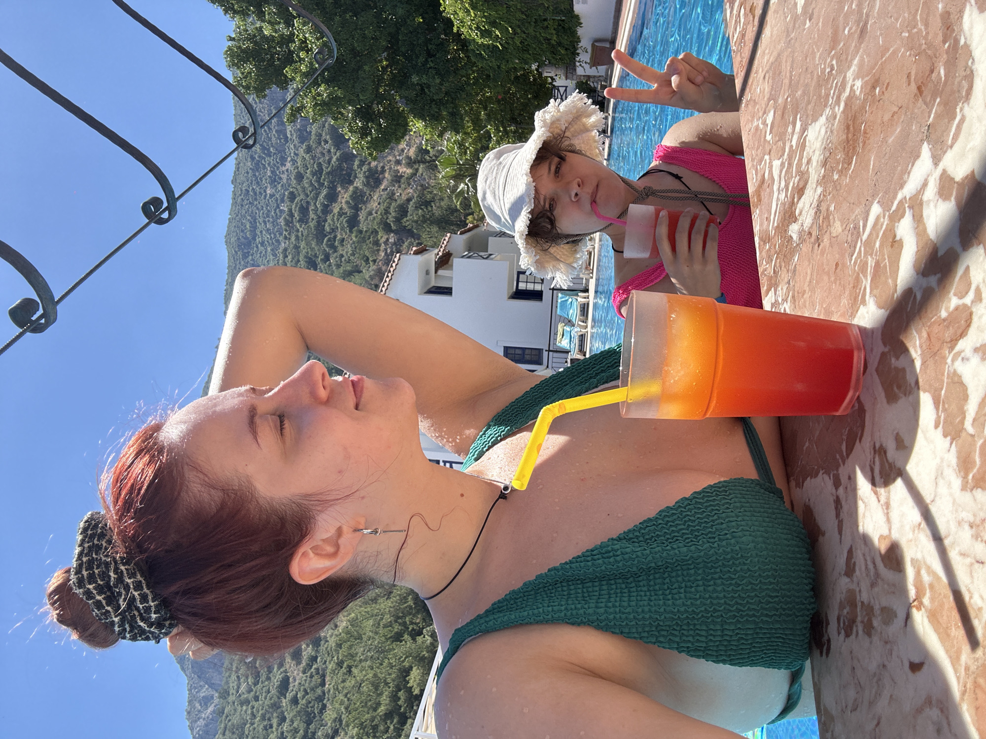 Two people relax poolside in sunny Fethiye resort