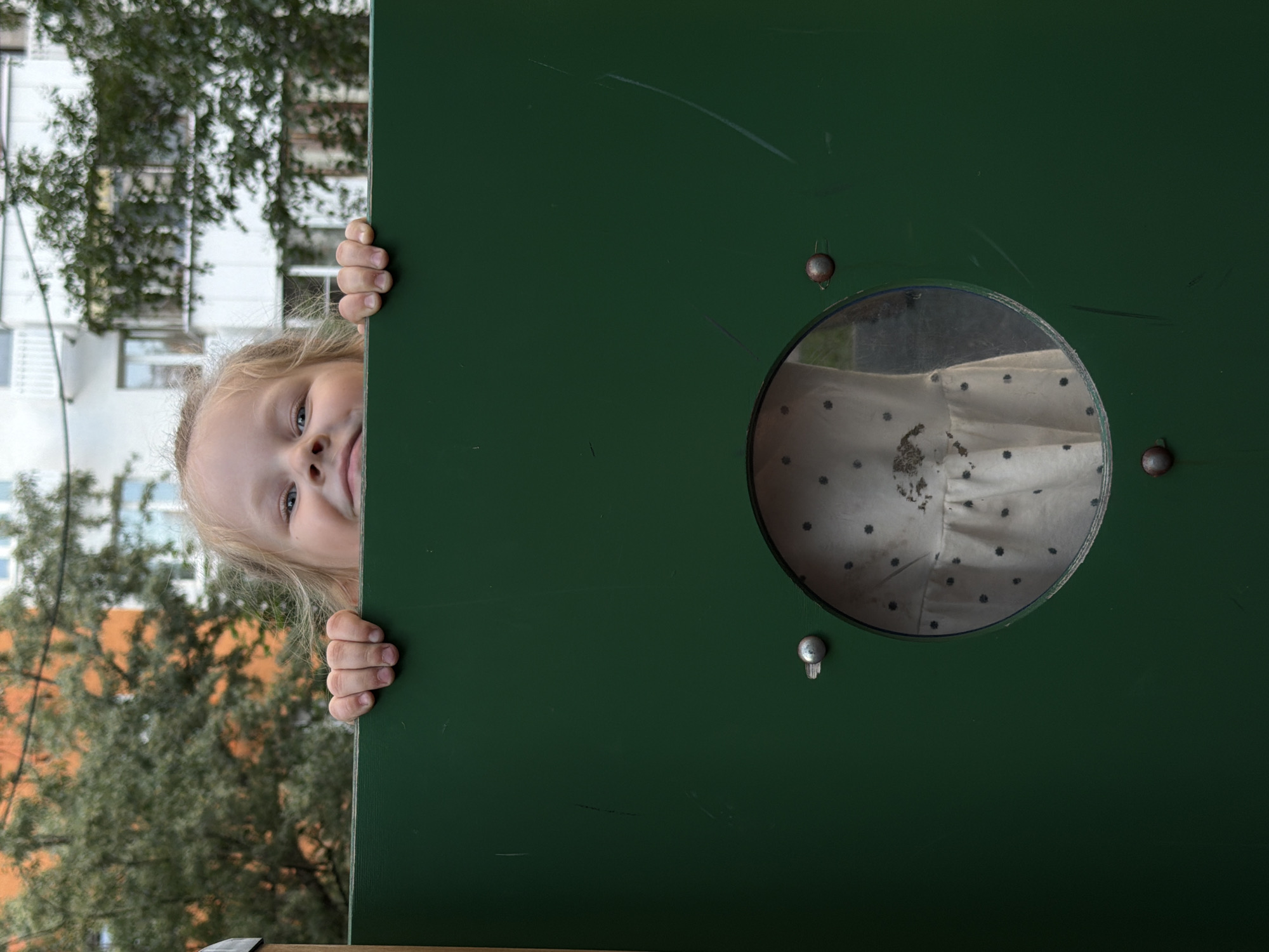 Child plays at Moscow playground equipment, climbs and cleans