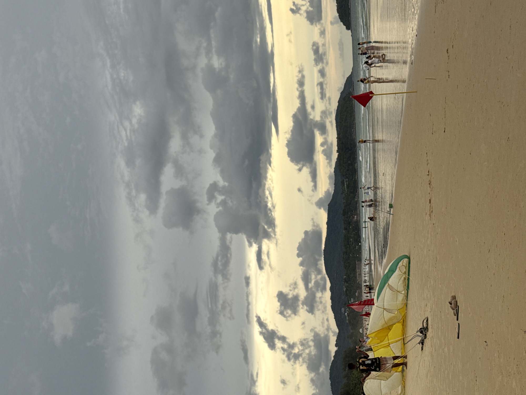 Sunset hours on Karon Beach, paragliding gear and golden skies