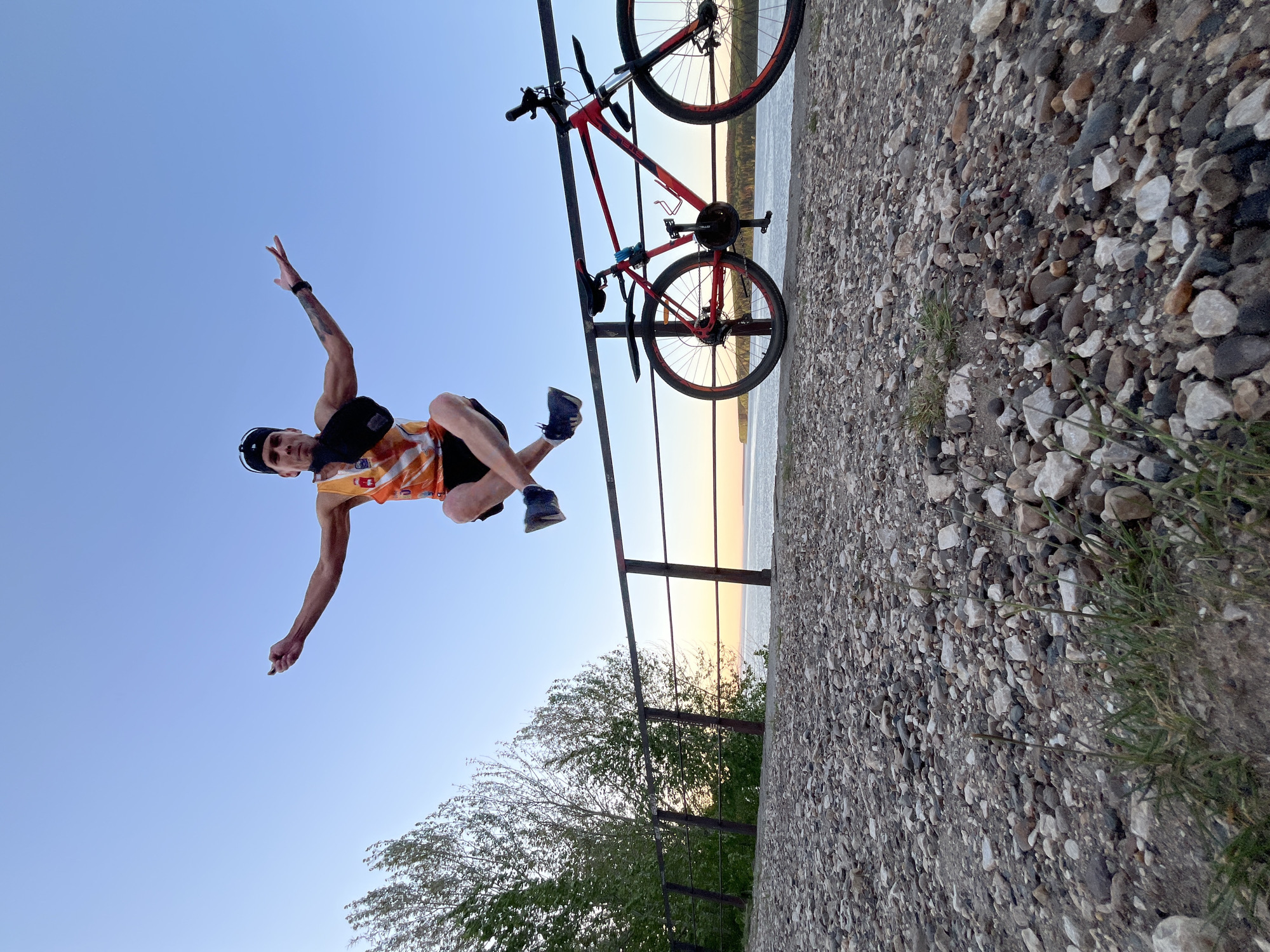 Cyclist performs stretches along Kama River waterfront in Chaikovsky