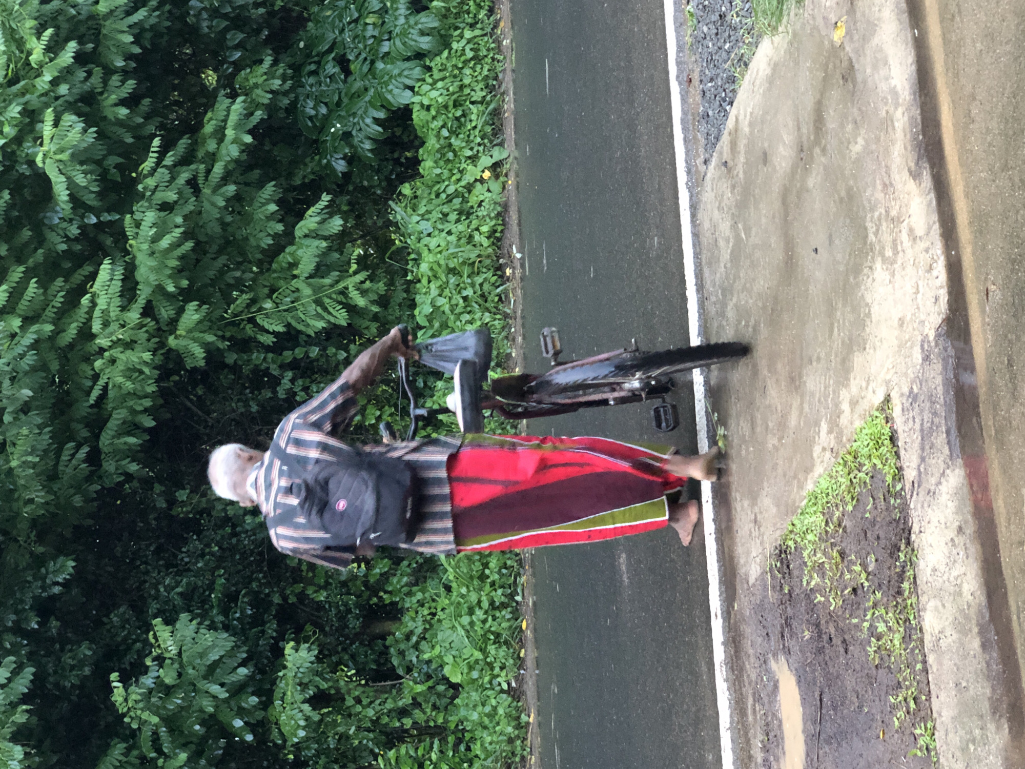 Cyclists moving through wet roads in Kodagoda after rain