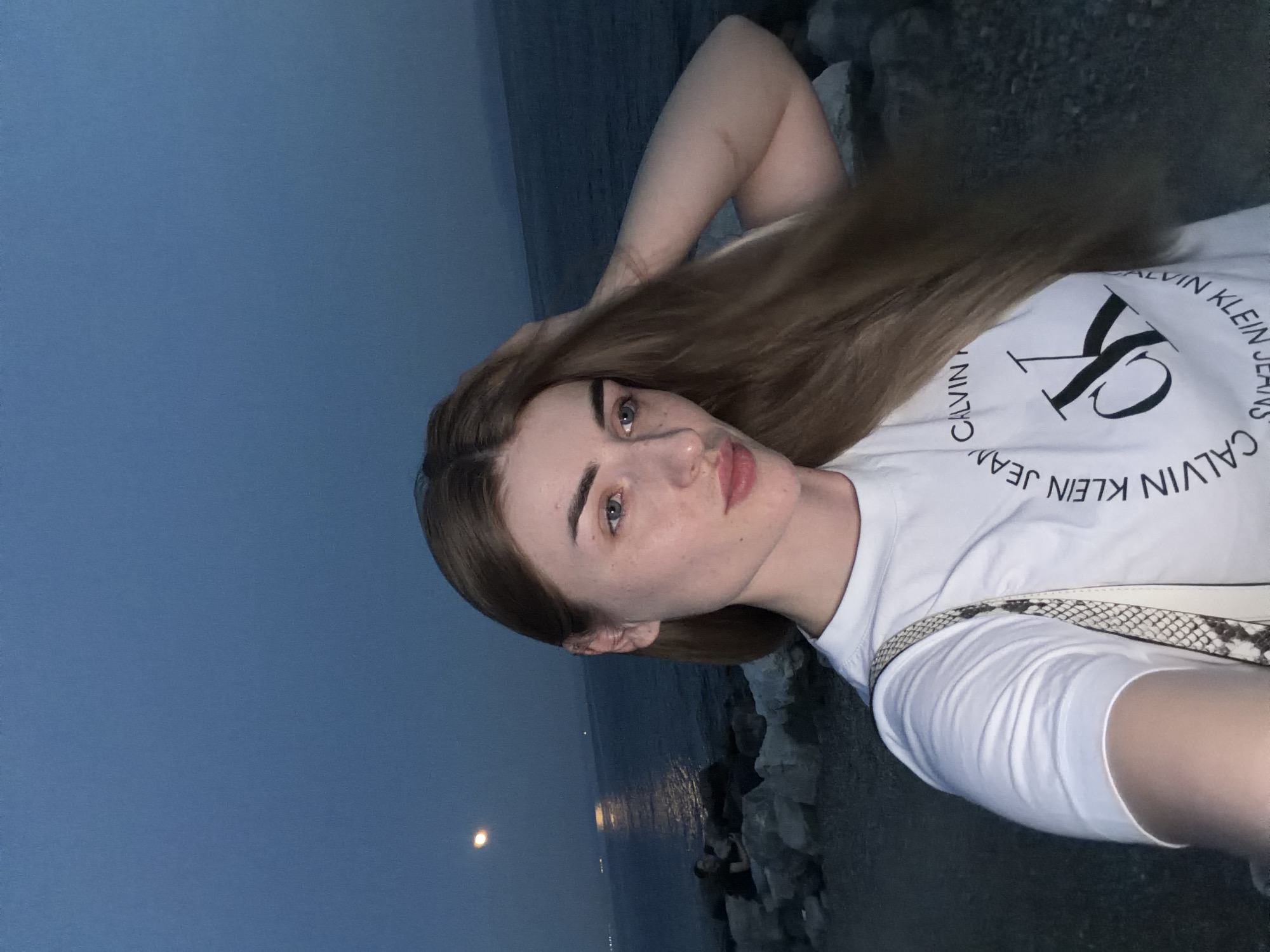 Selfies on a rocky shore at dusk, full moon rising