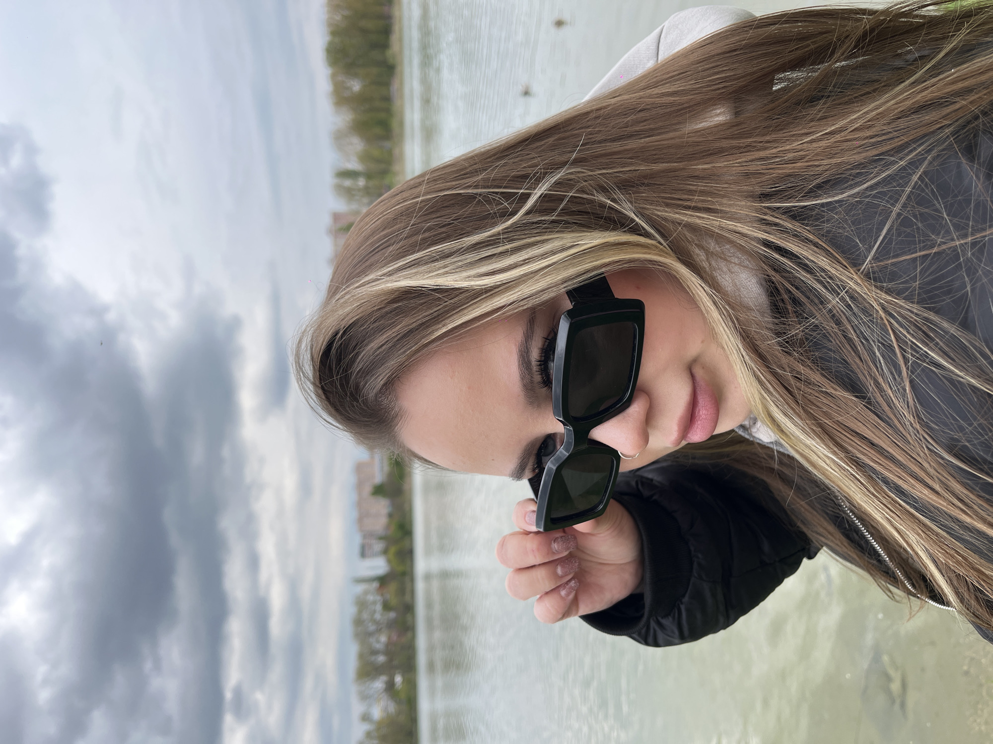 Woman documents leisurely afternoon by Krasnodar waterway, observing ducks
