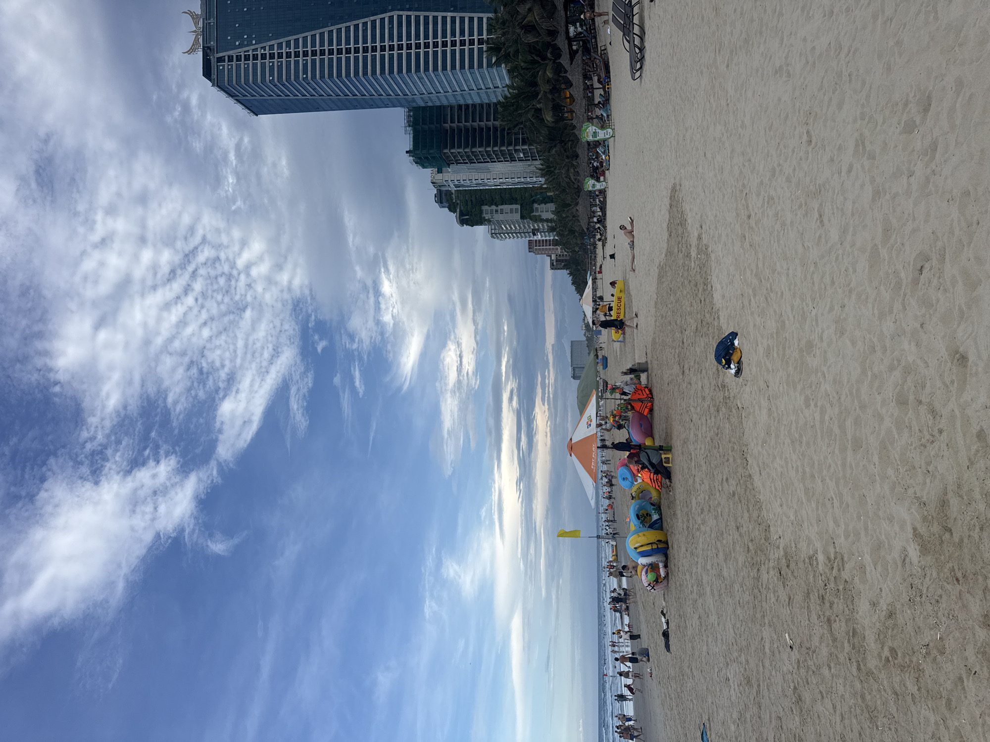Urban beach bustling with visitors under dramatic stormy skies