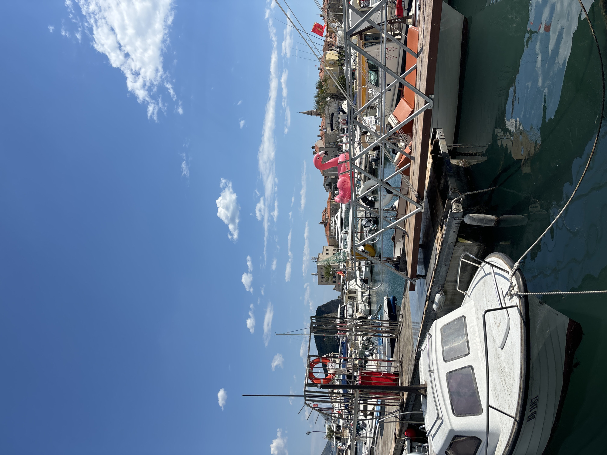 Tourists explore Budva marina and old town during sunny afternoon