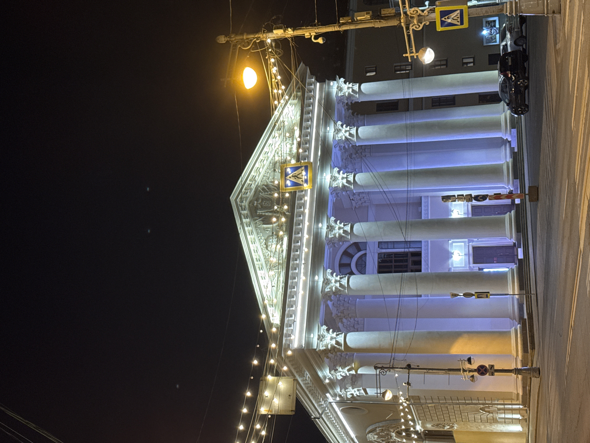 Illuminated classical building observed in evening Tver streetscape