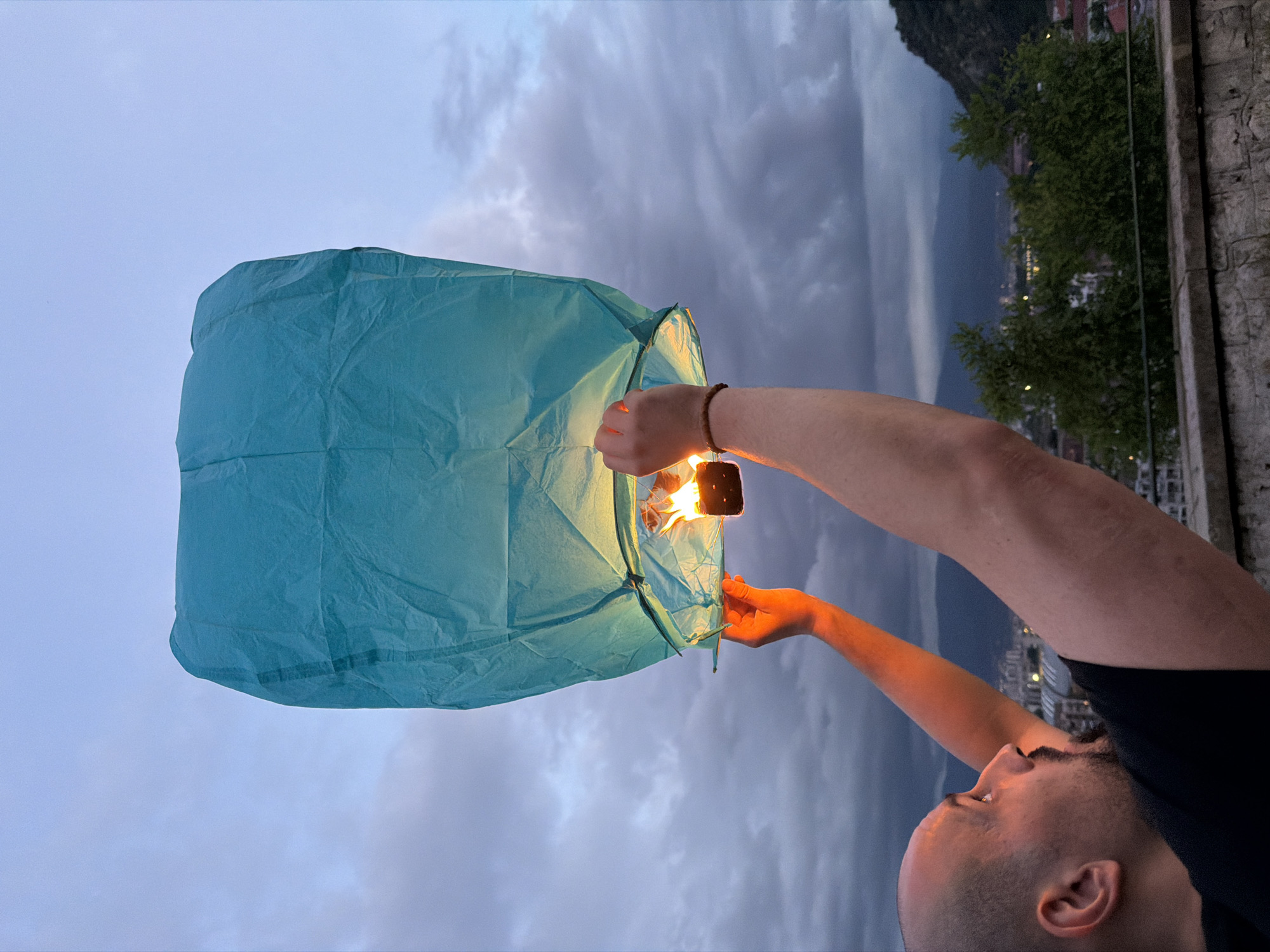 Man releases blue sky lantern at dusk in Plovdiv