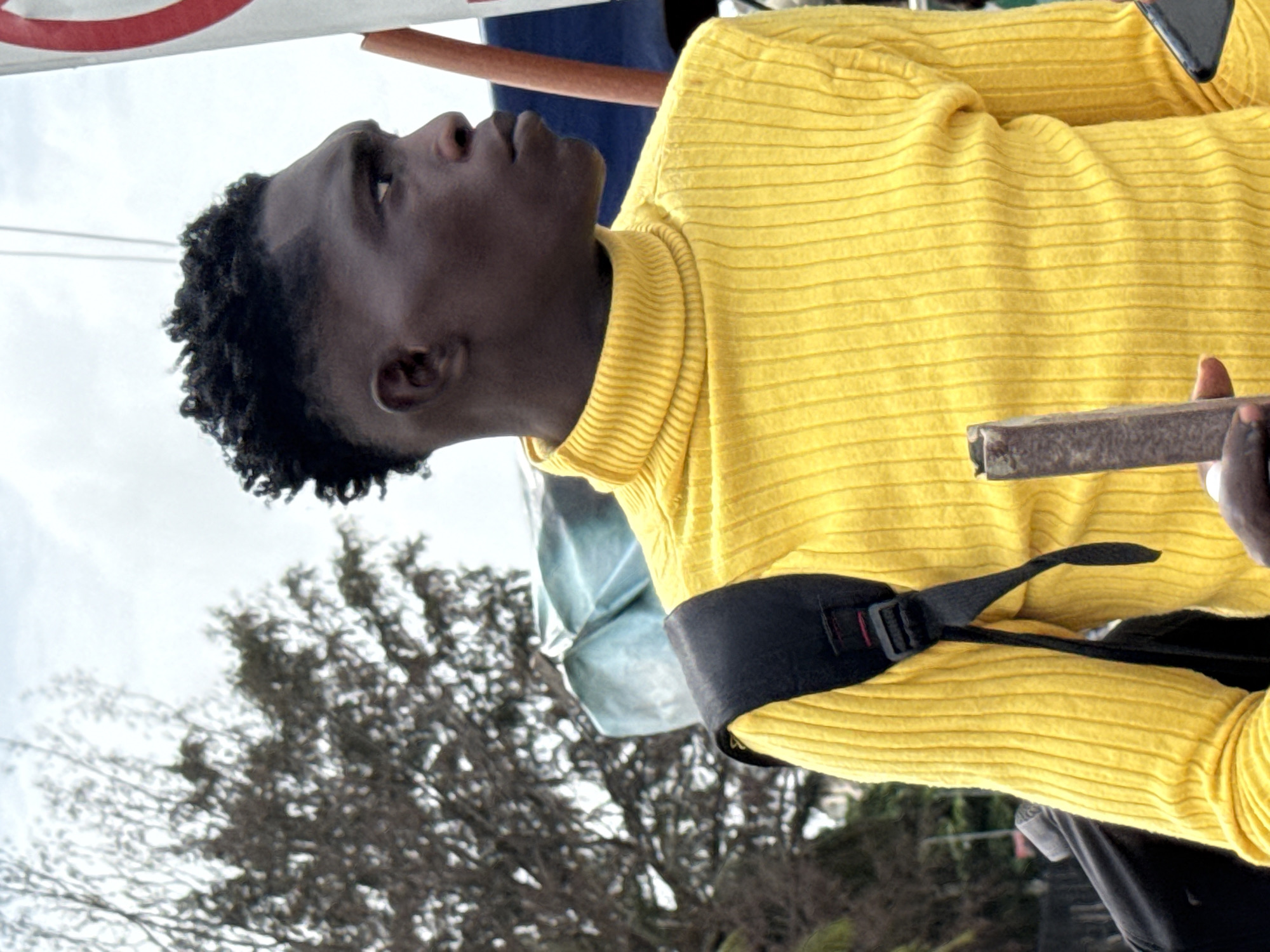Young man observed looking upward in Nigerian marketplace