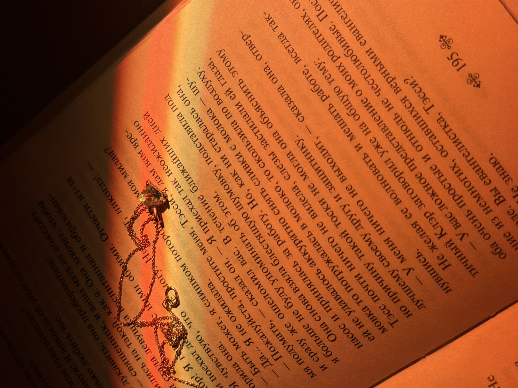 Gold necklace placed on open Russian book in Chaikovsky