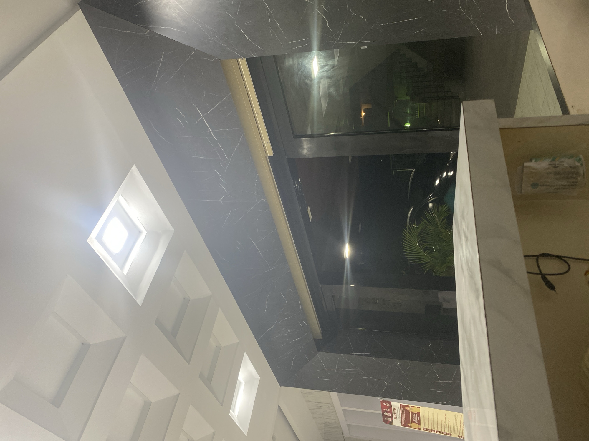 Modern marble lobby interior with coffered ceiling and recessed lighting