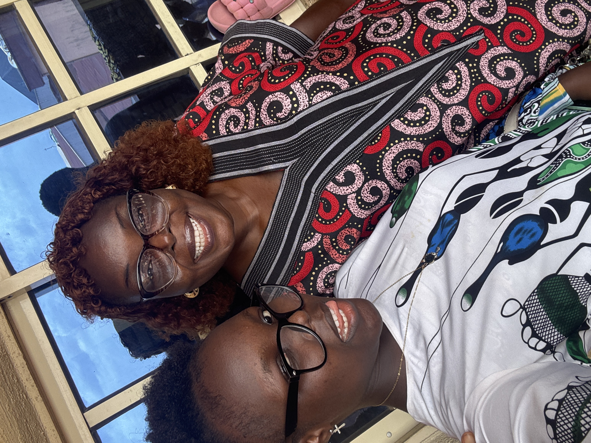 Women pose for photos in colorful Sunday attire in Onitsha