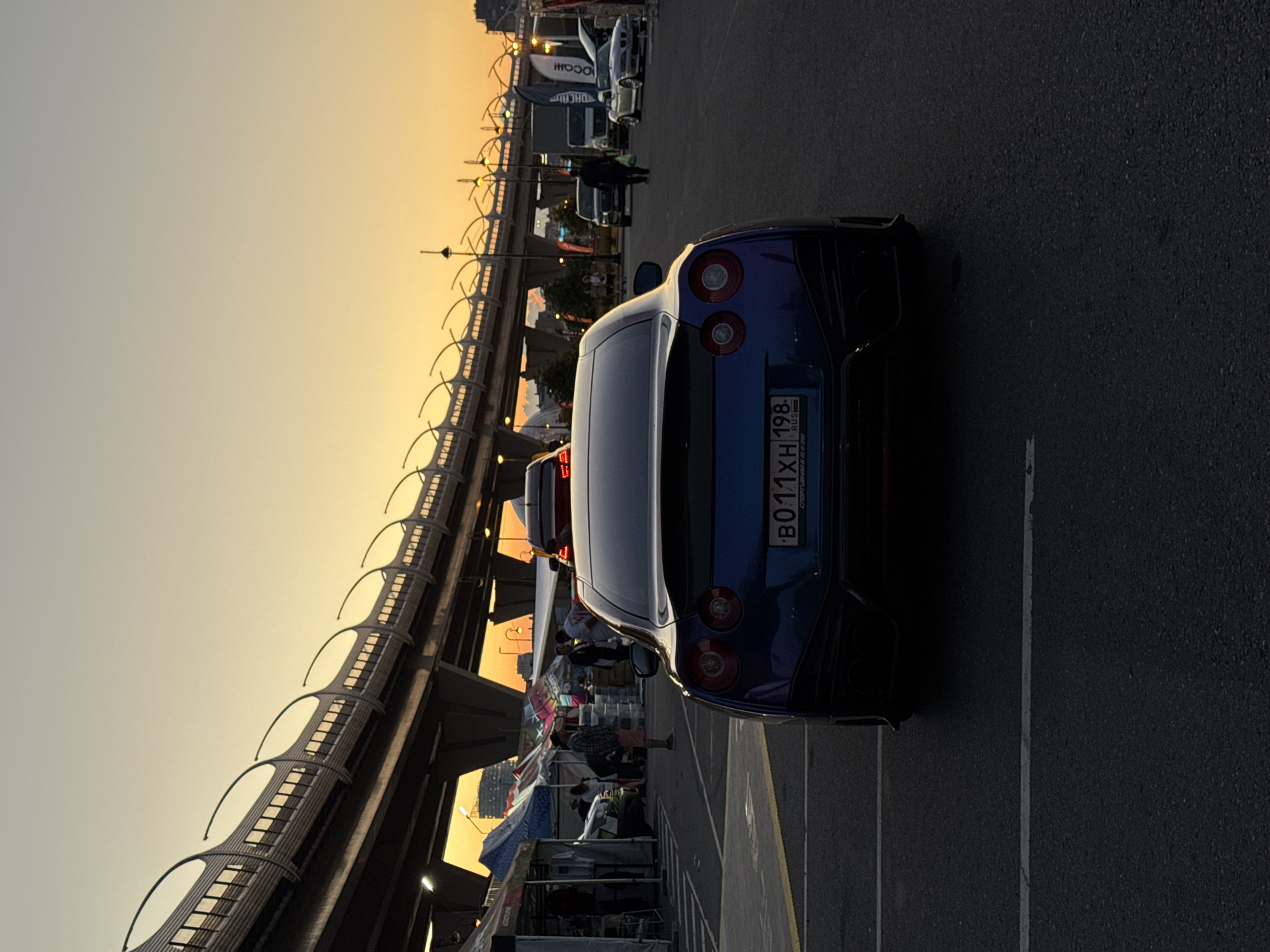 Performance cars and a tow truck near a St. Petersburg overpass