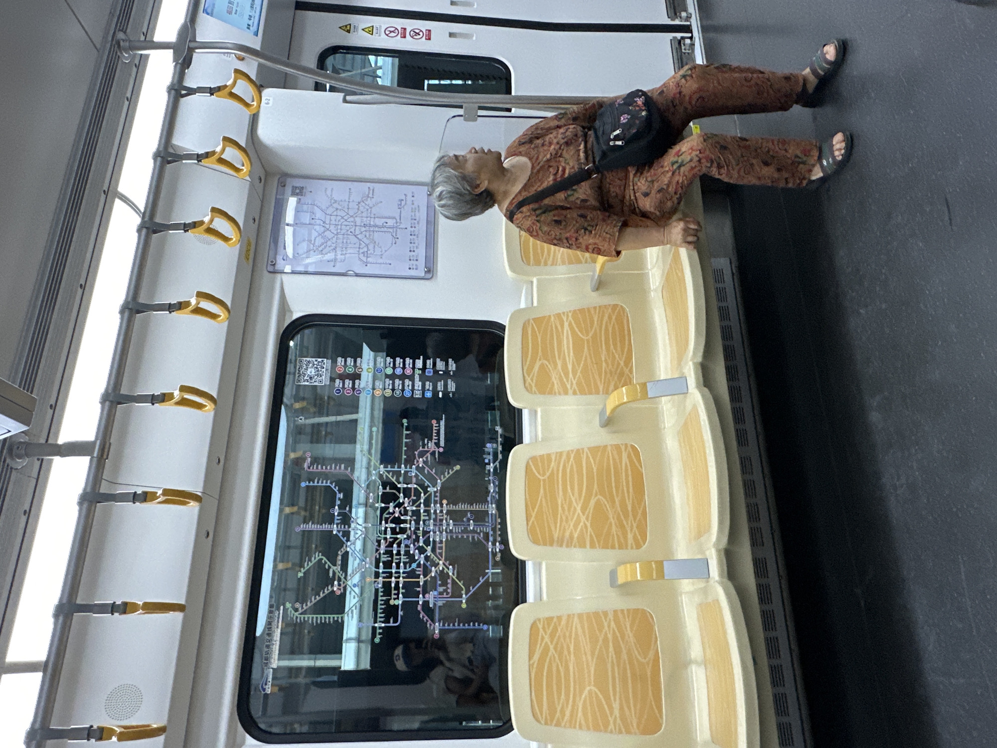 Elderly passenger stretches across empty train seats in Jianyang
