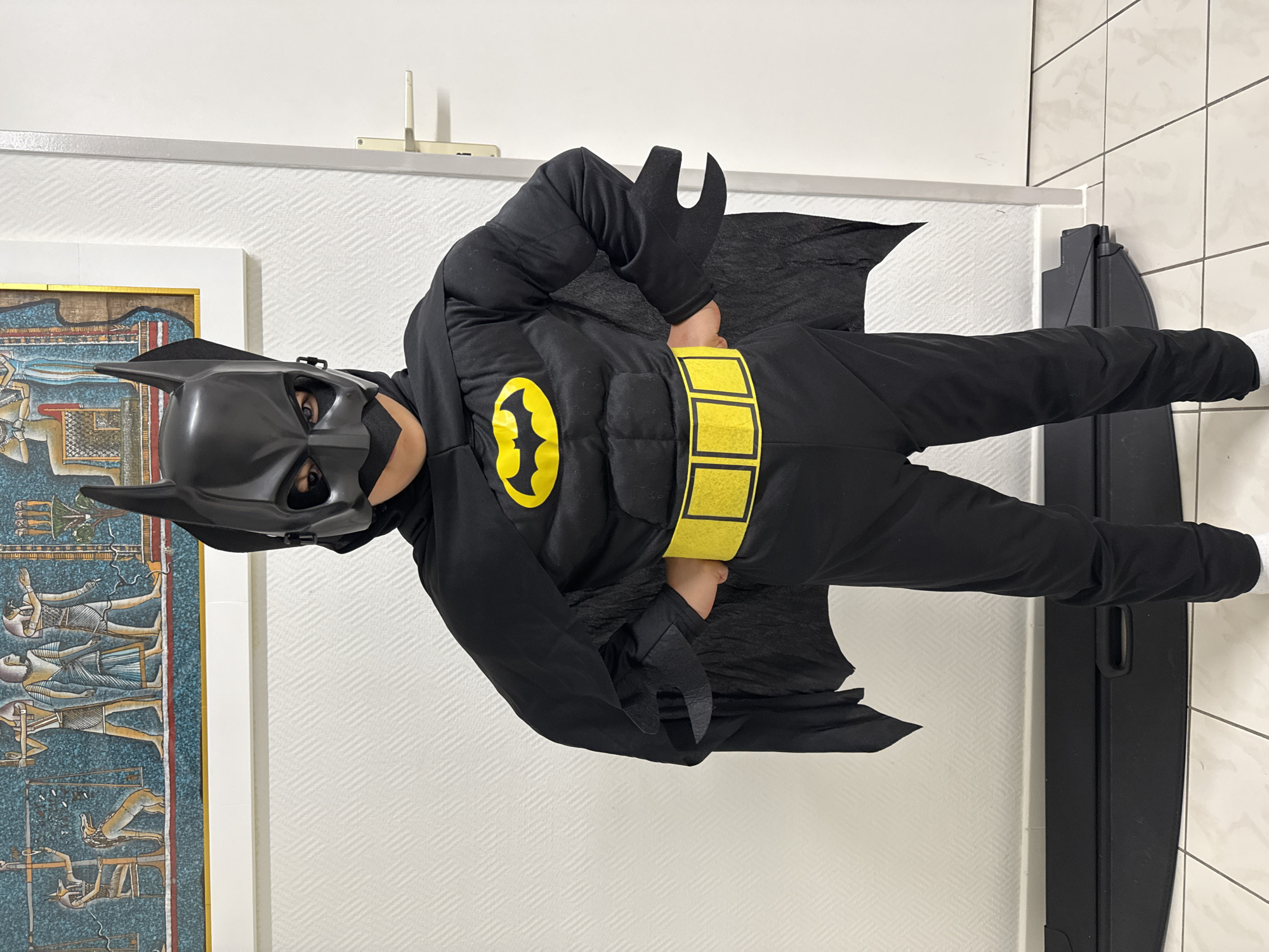 Child in Batman costume spotted indoors in Pétange, Luxembourg