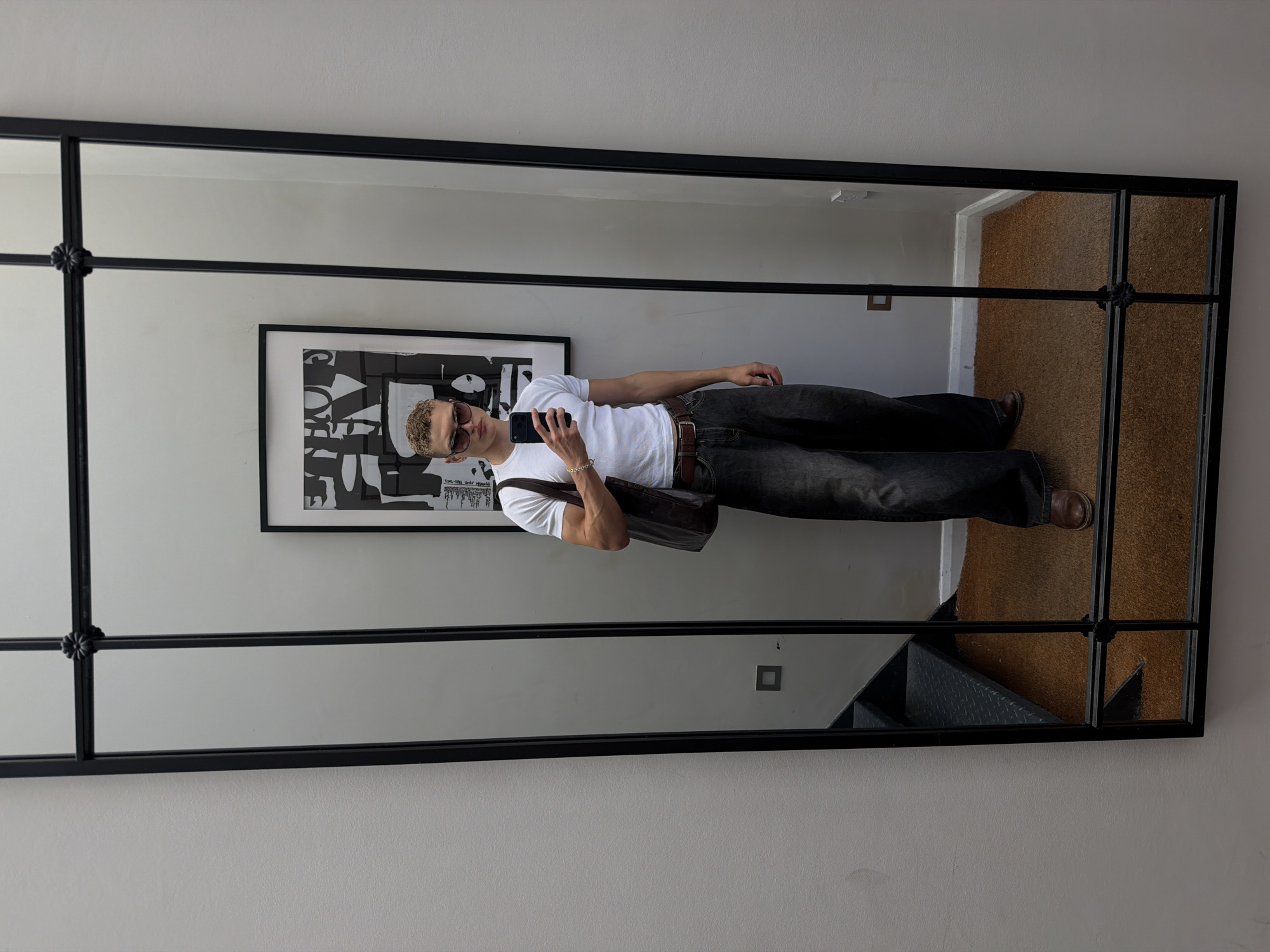 Mirror selfie with a bold black-framed multi-panel backdrop