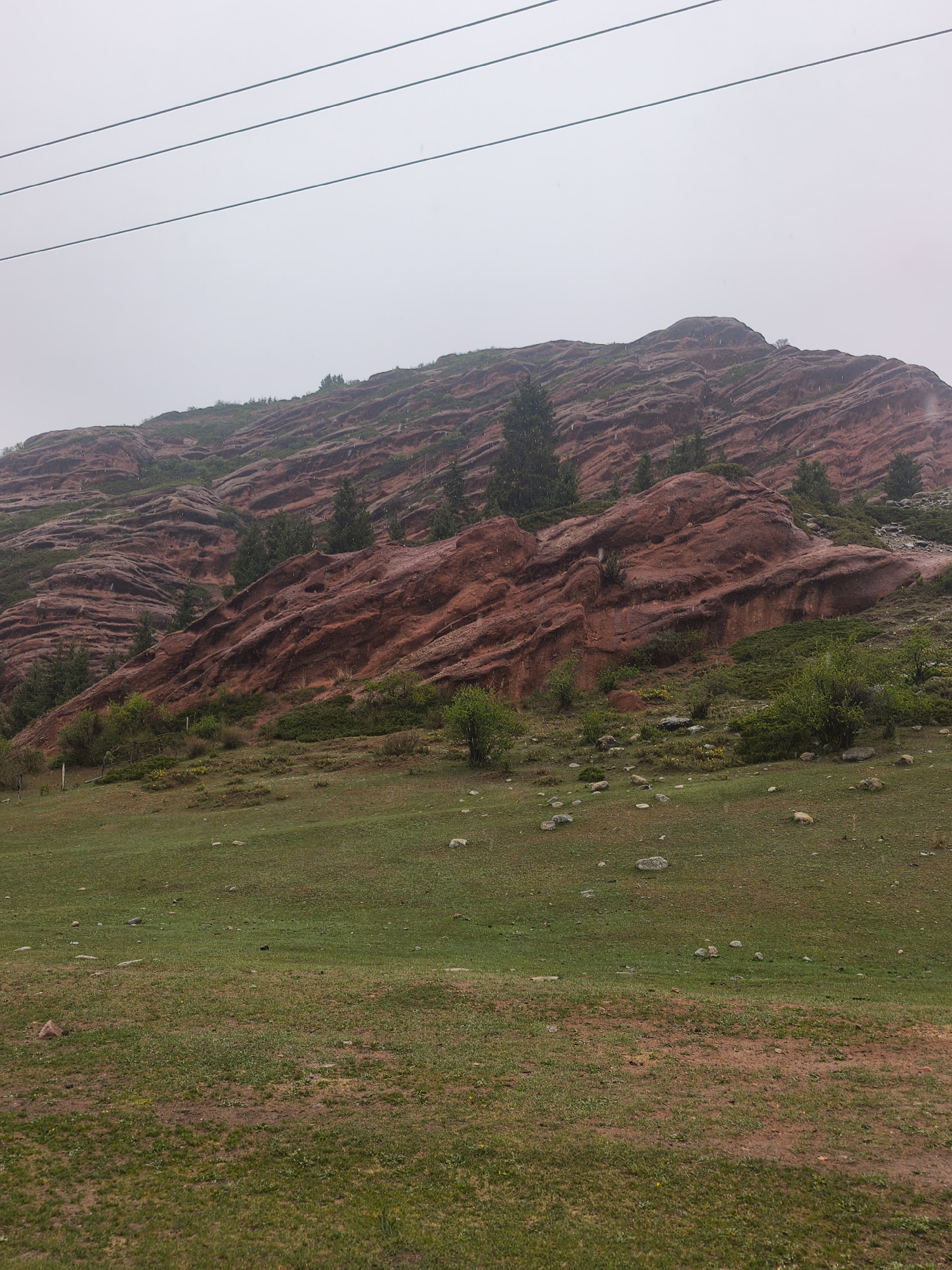Red rock formations observed under overcast skies in Kyrgyzstan