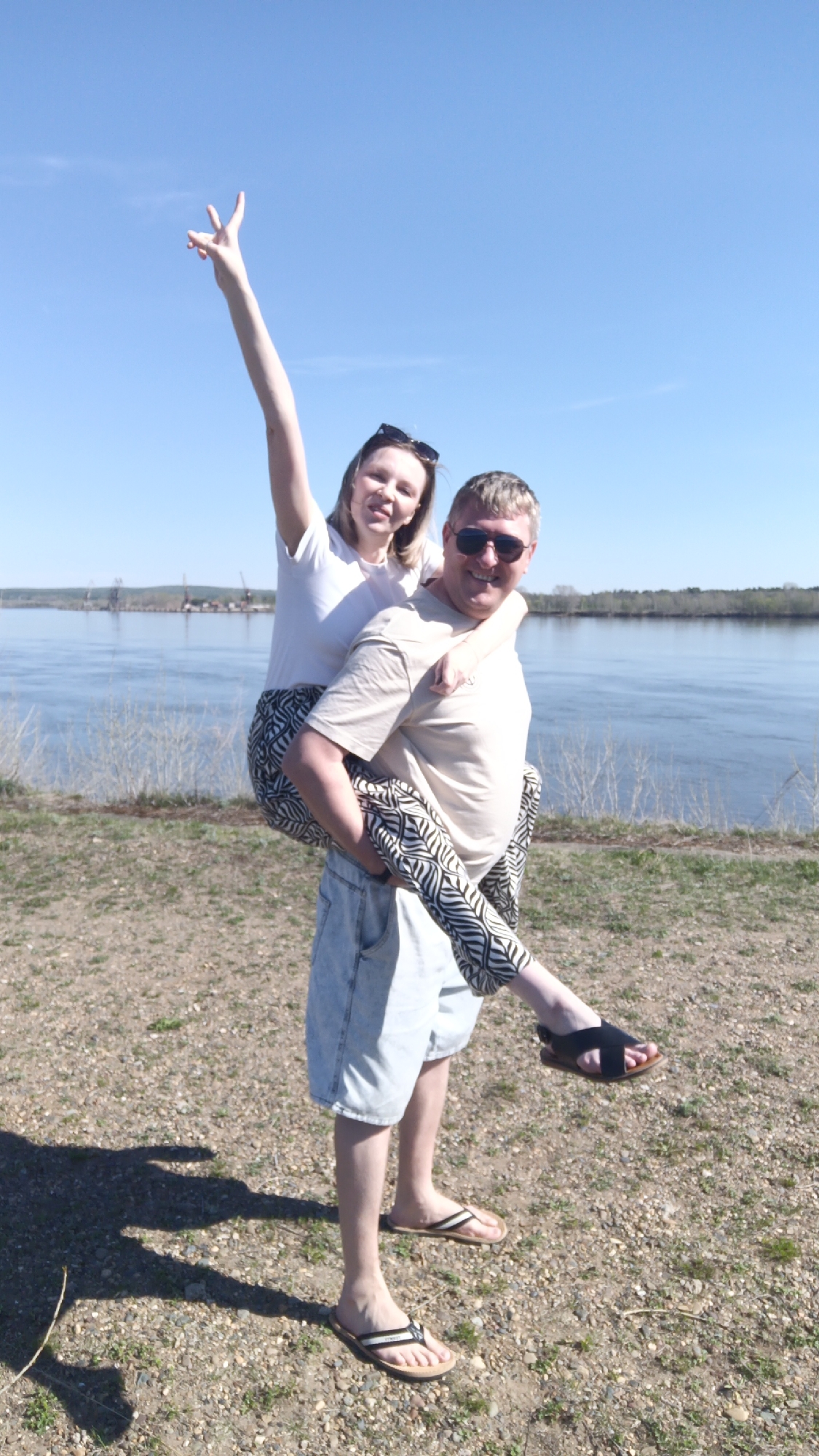Piggyback ride witnessed along riverbank in Chaikovsky, Russia