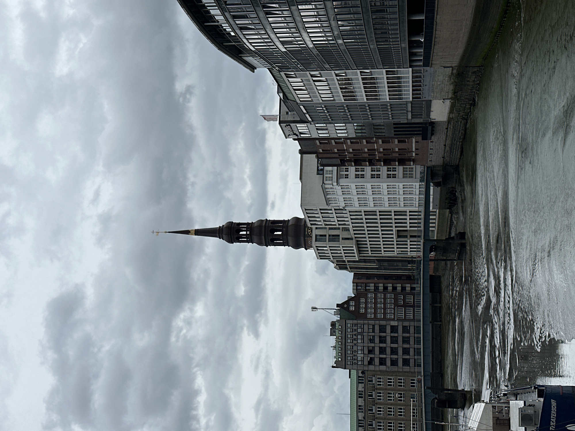 Tourist documents overcast Hamburg waterfront and Gothic architecture