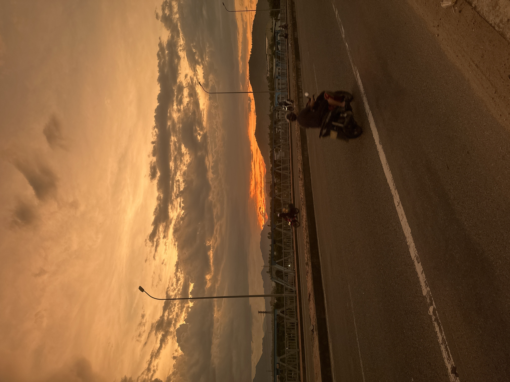 Bridge traffic flows through a fiery Da Nang sunset