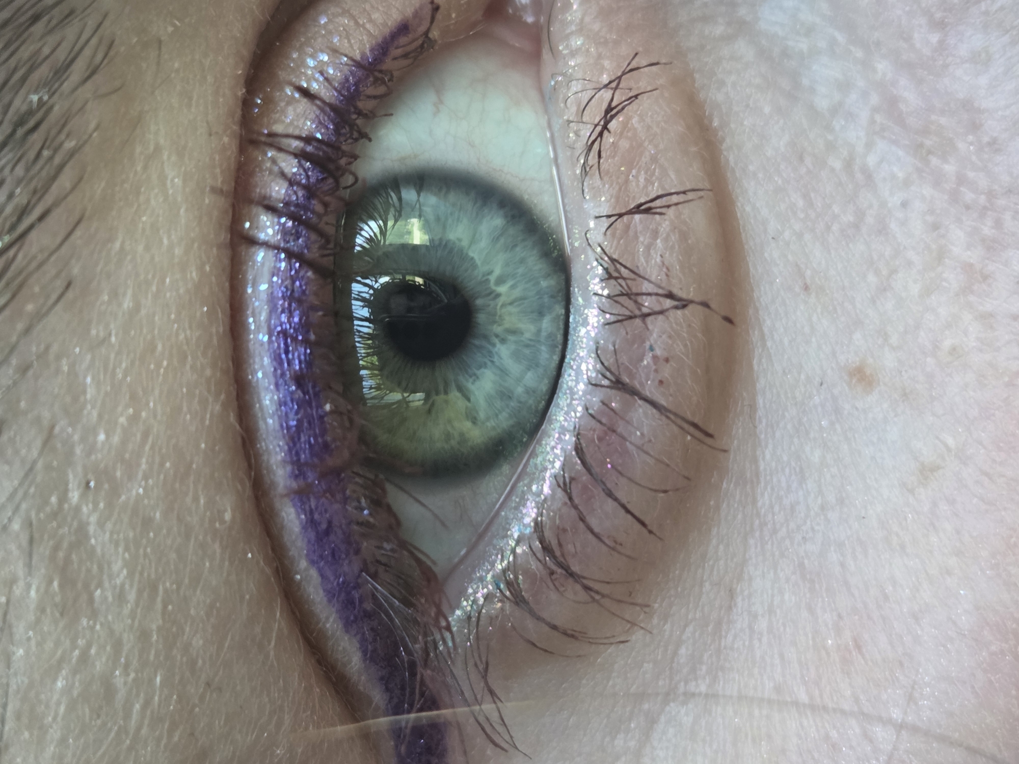 Person Takes Selfies in Heart-Shaped Mirror With Purple Makeup