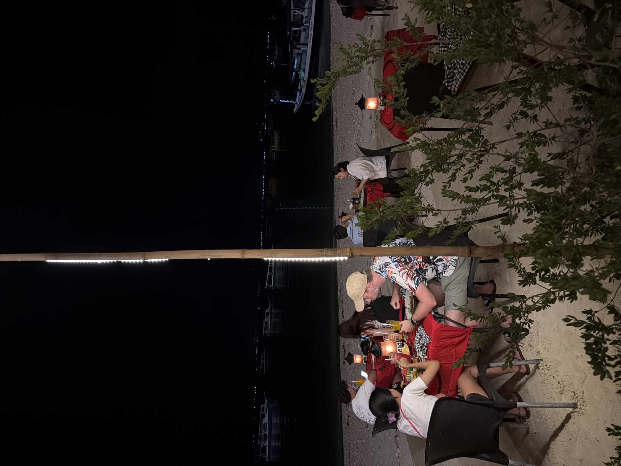 Beachside restaurant serves diners under lanterns in Indonesia