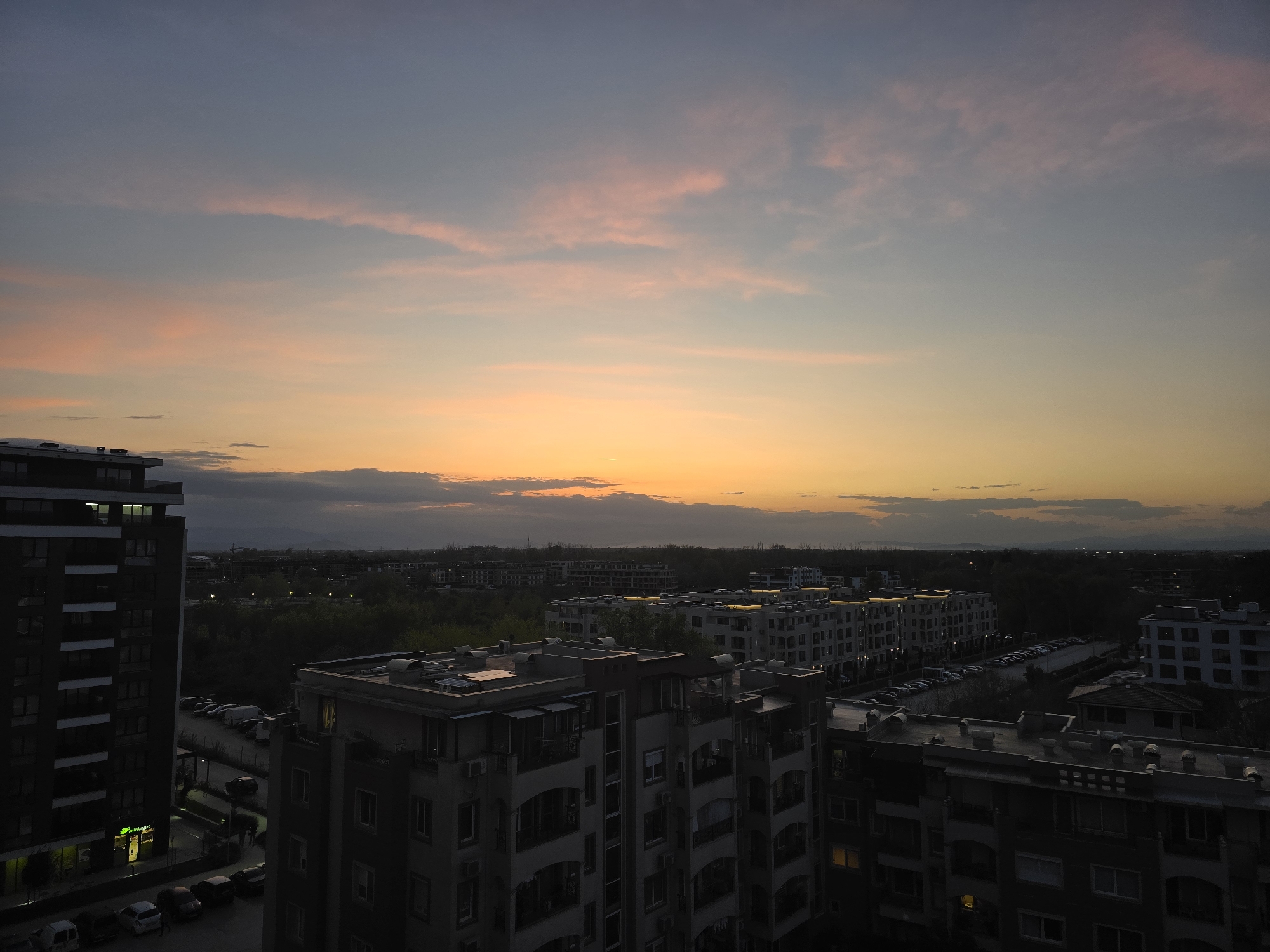 Sunset captured over water and cityscape during evening hours