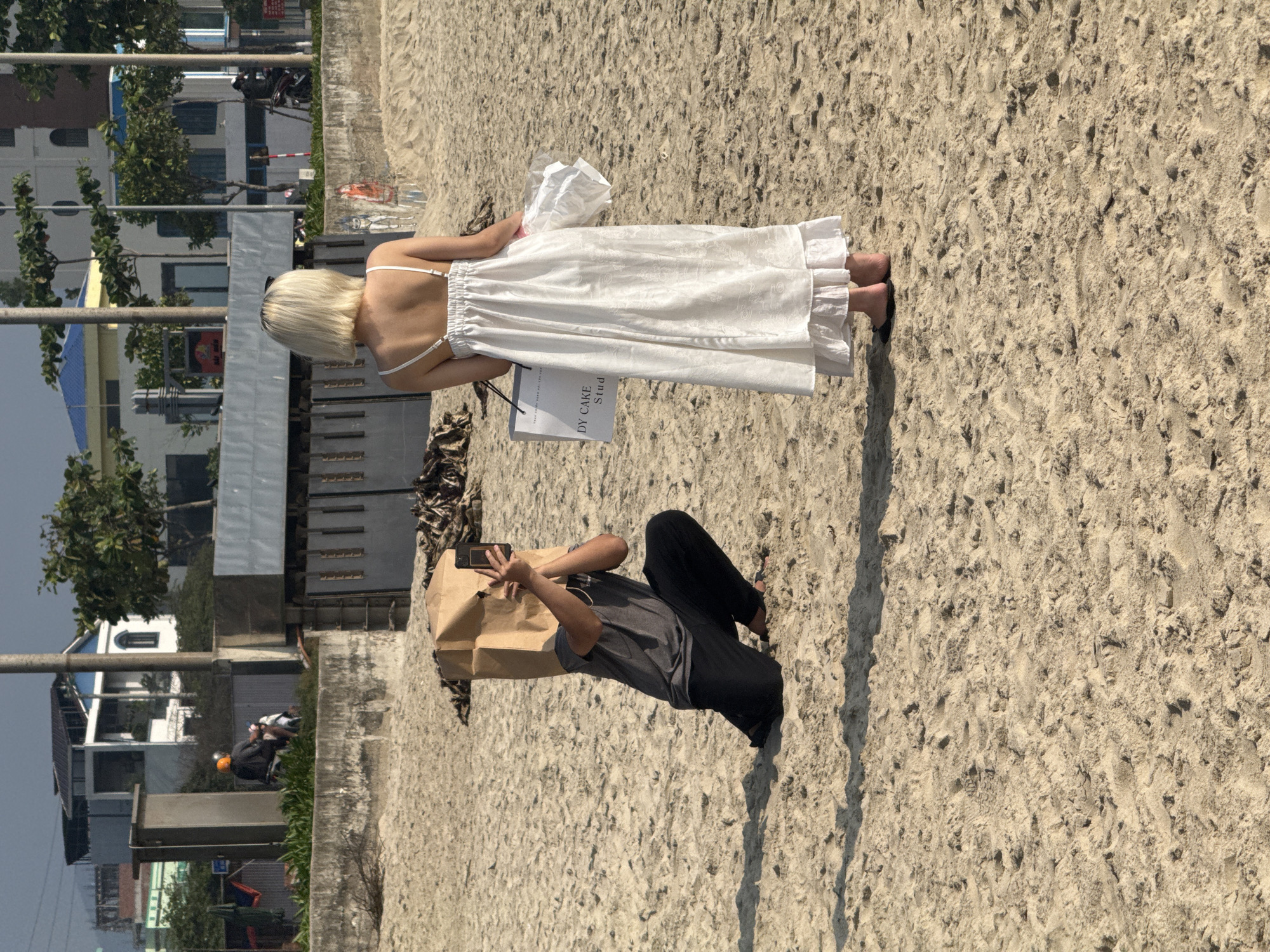 Couple photographed on beach in Đà Nẵng with shopping bags