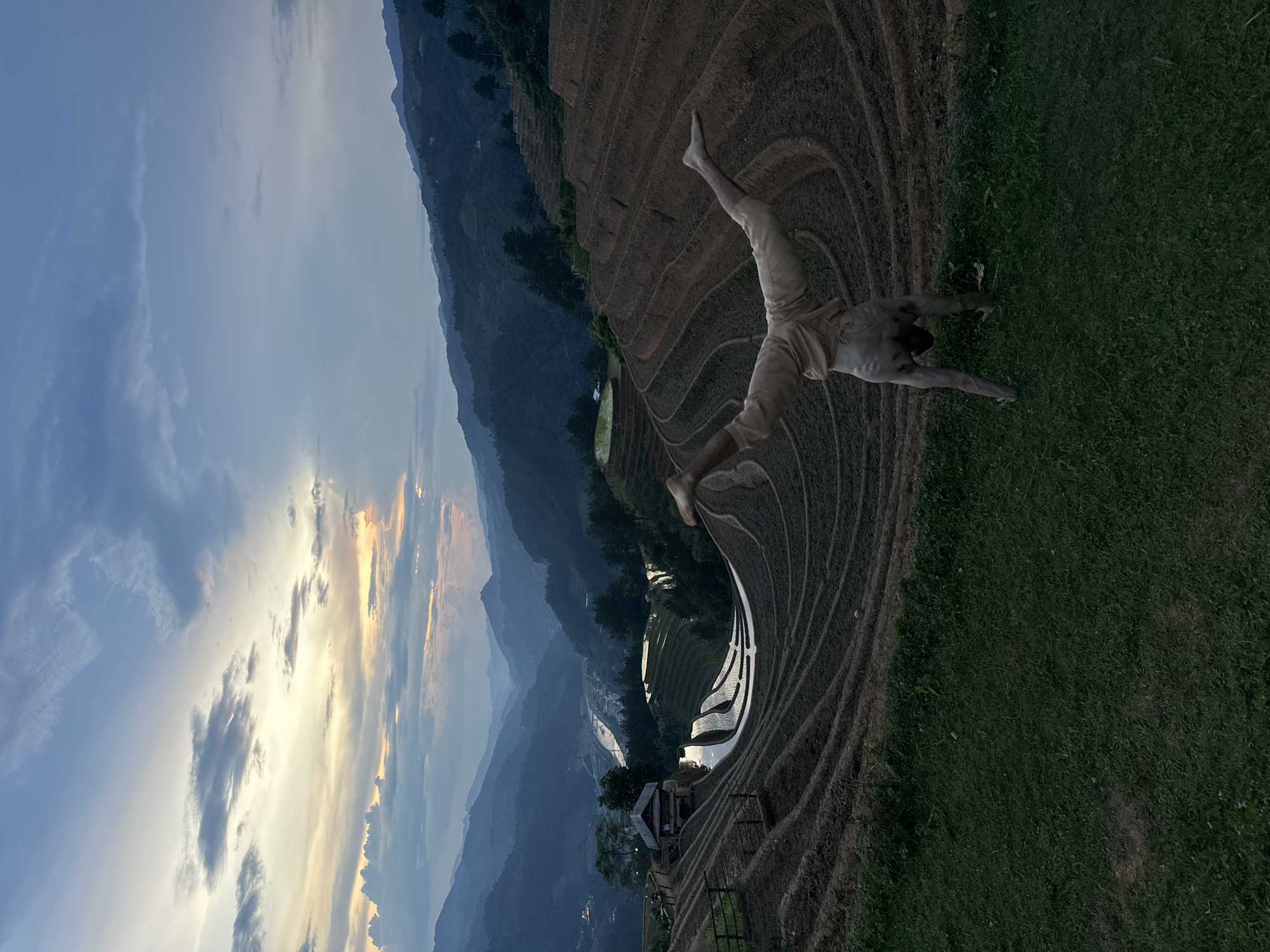 Tourist poses at Vietnam's terraced rice fields during twilight