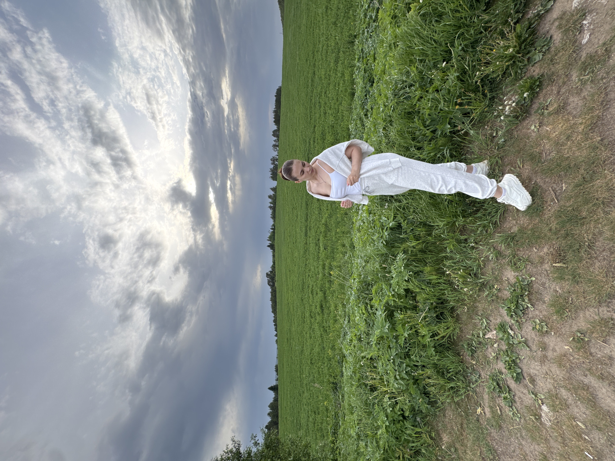 Woman in white poses on rural road in Lukintsy