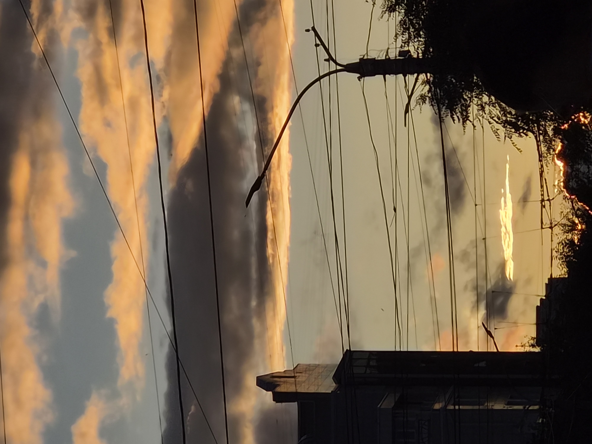 Modern architecture in silhouette against a dramatic sunset sky
