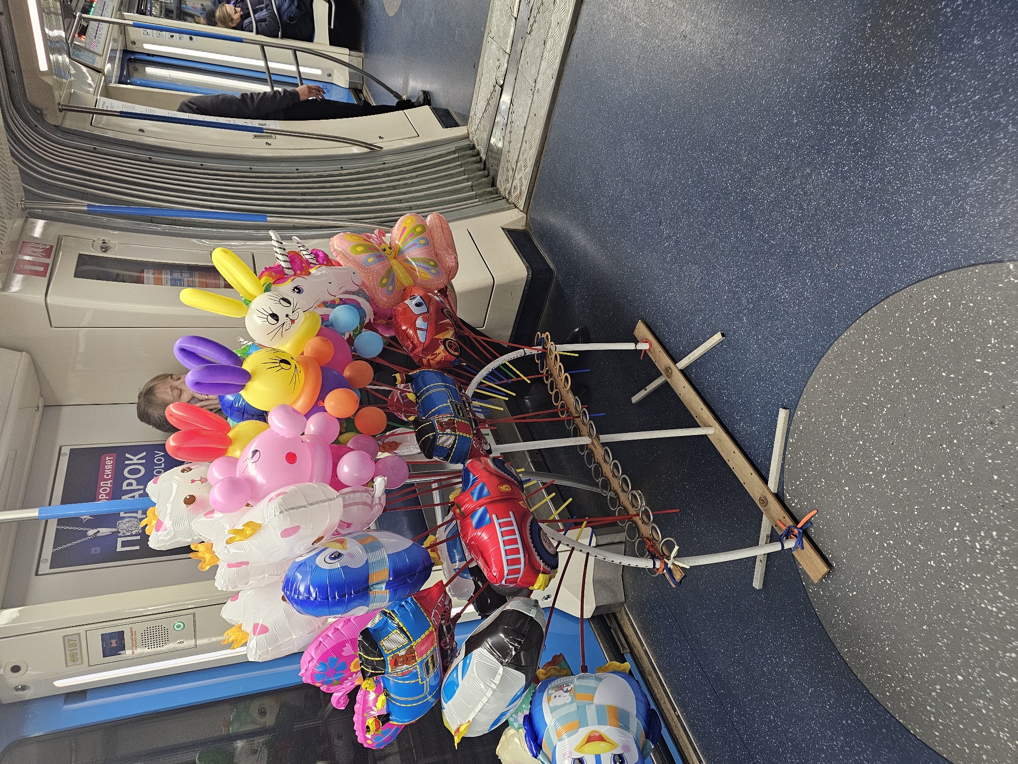 Balloon vendor sells animal-shaped balloons on Moscow Metro train