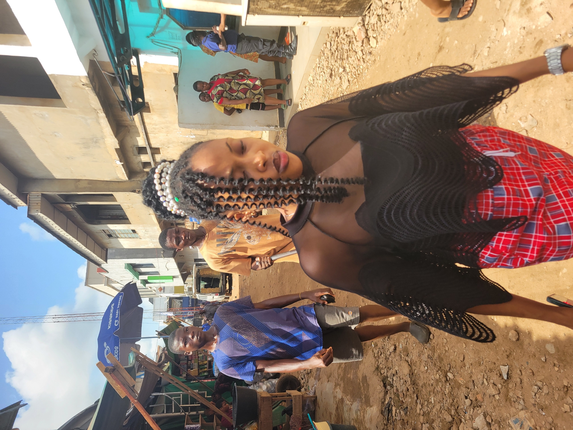 Woman in traditional attire photographed in sunlit Onitsha scene