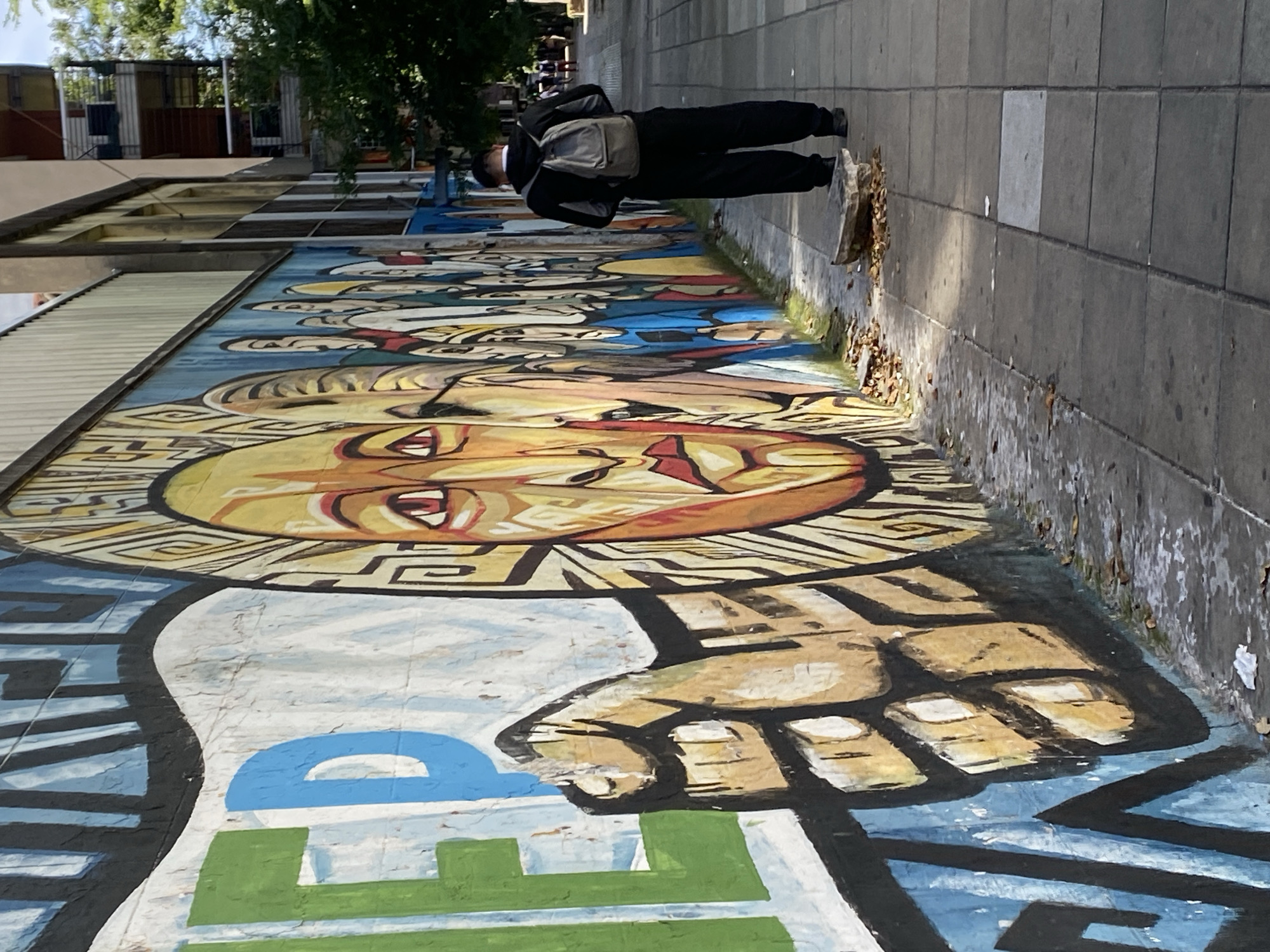 Colorful street mural with faces and fist observed in Buenos Aires