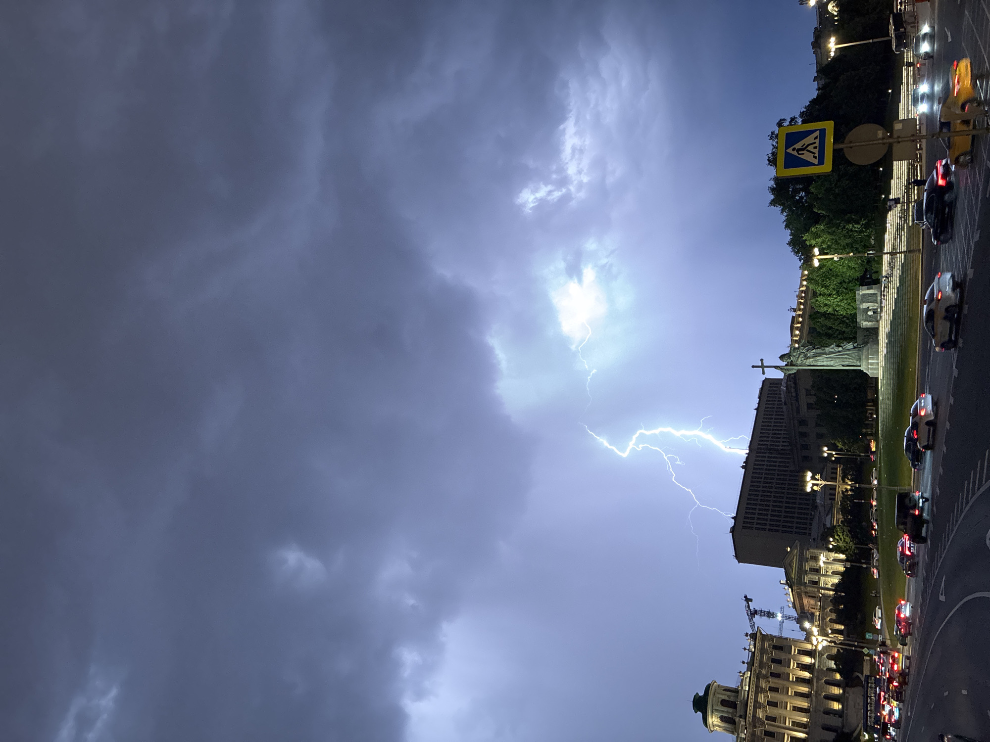 Lightning strike illuminates city buildings during nighttime storm