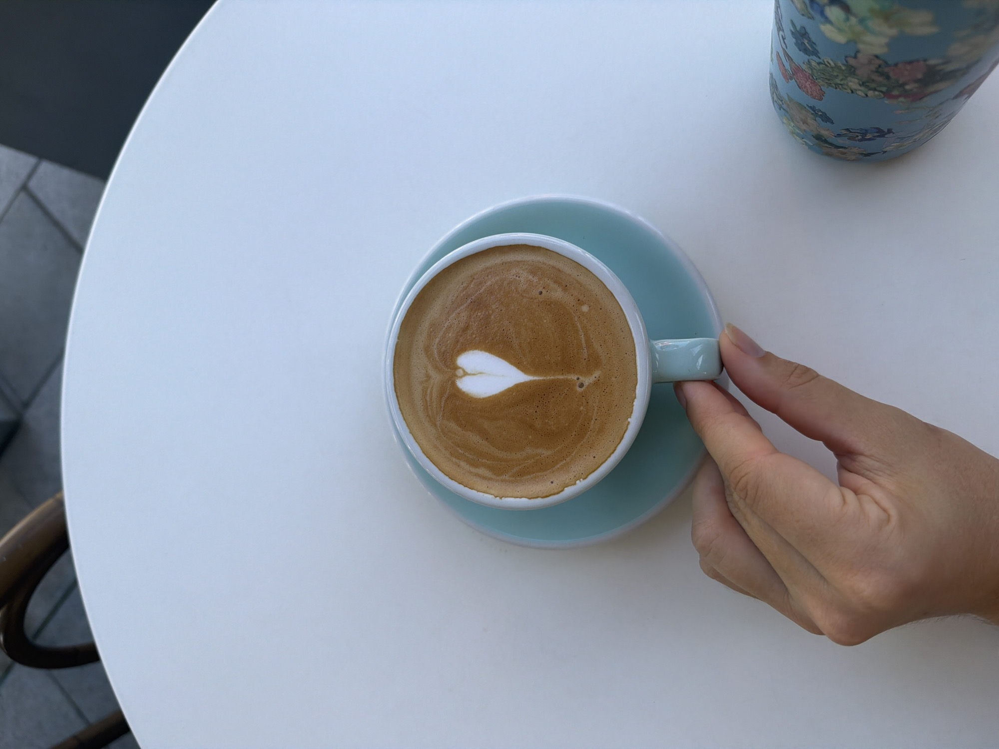 Latte art coffee moment at a white table in Bat Yam