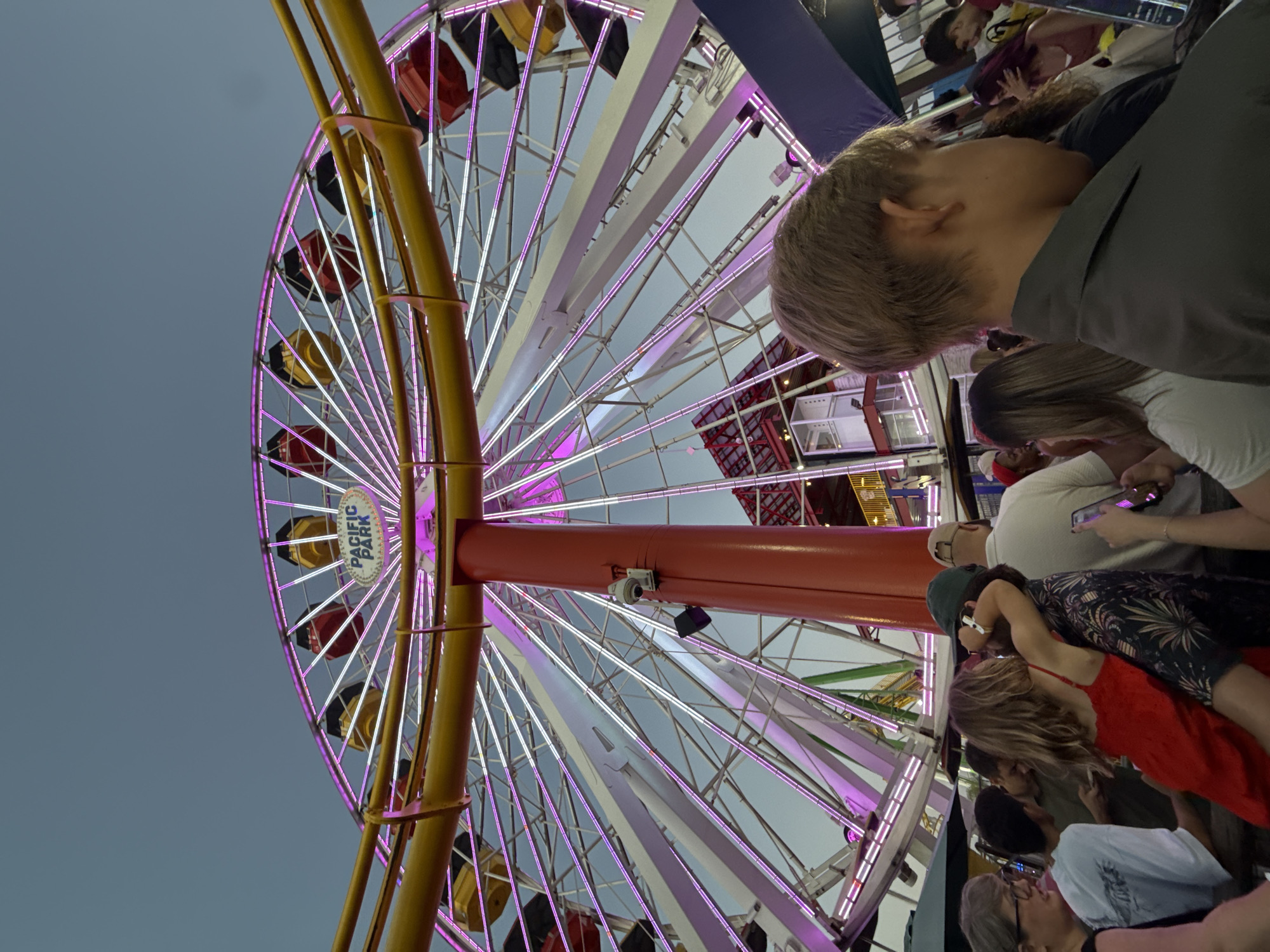 Pacific Park Ferris wheel glowing at dusk on the Santa Monica Pier