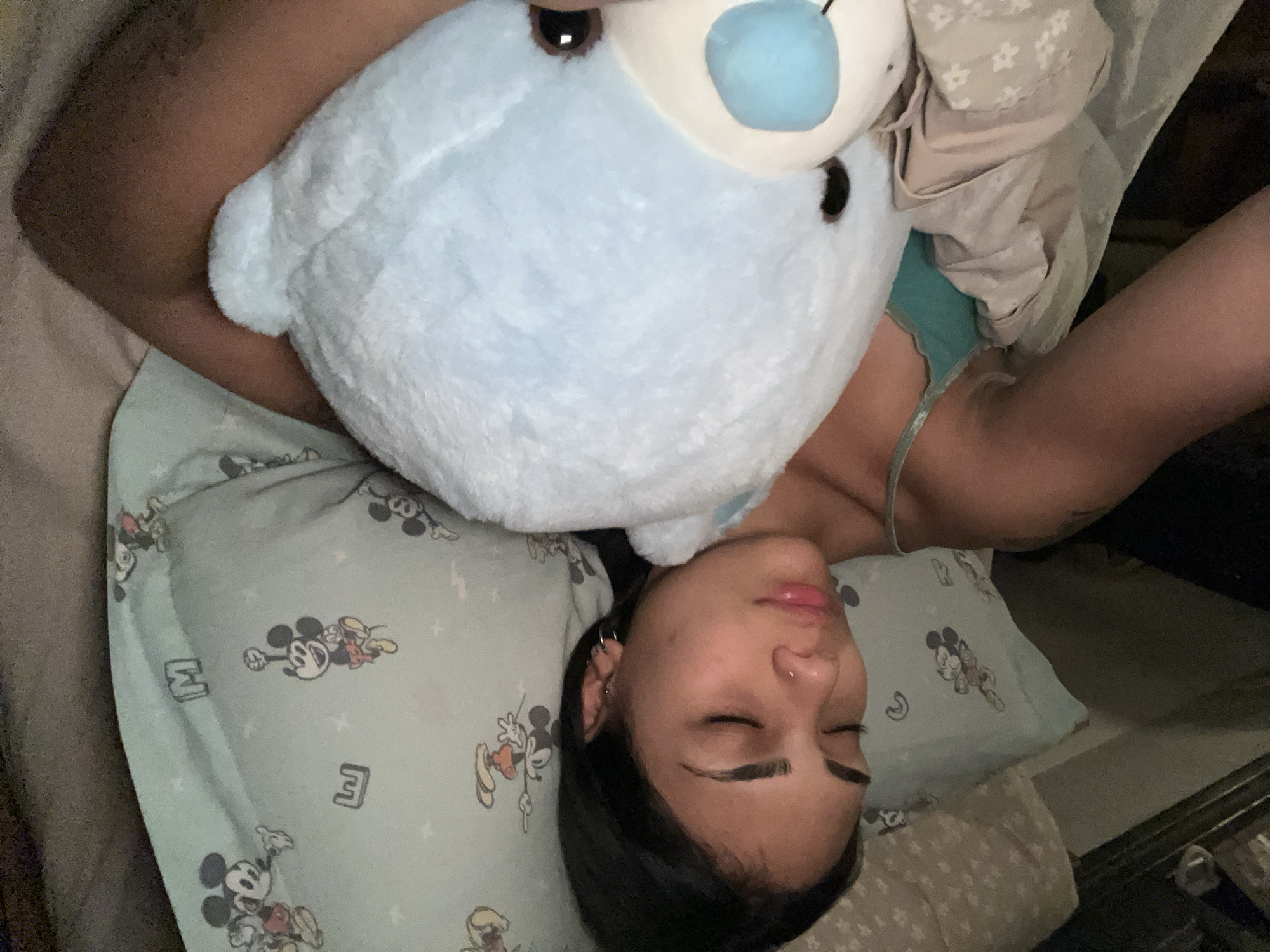 Person sleeps peacefully with teddy bear in Buenos Aires bedroom