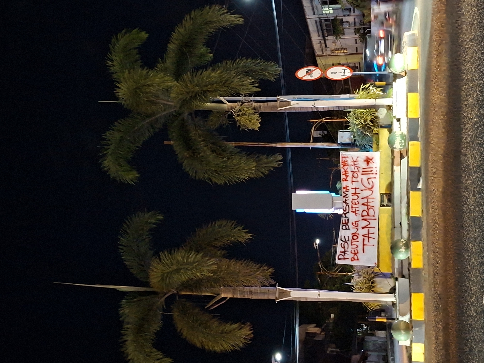 Anti-mining protest banner spotted amid everyday scenes in Lhokseumawe