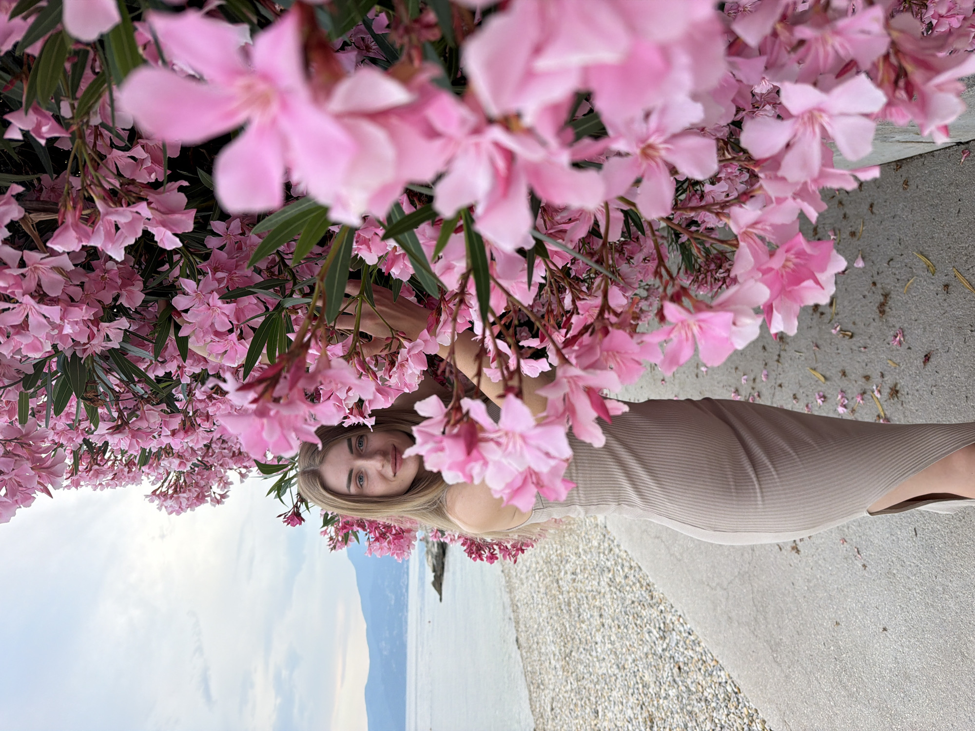 Beach and oleander flower photo session in a beige ribbed dress