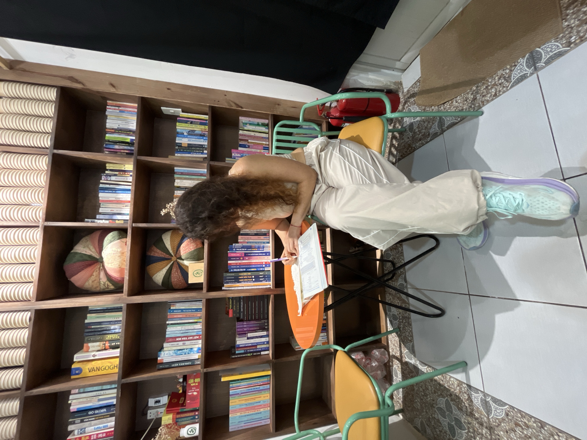 Writing and coffee at a bookshelf-lined café in Phu Thuy Ward