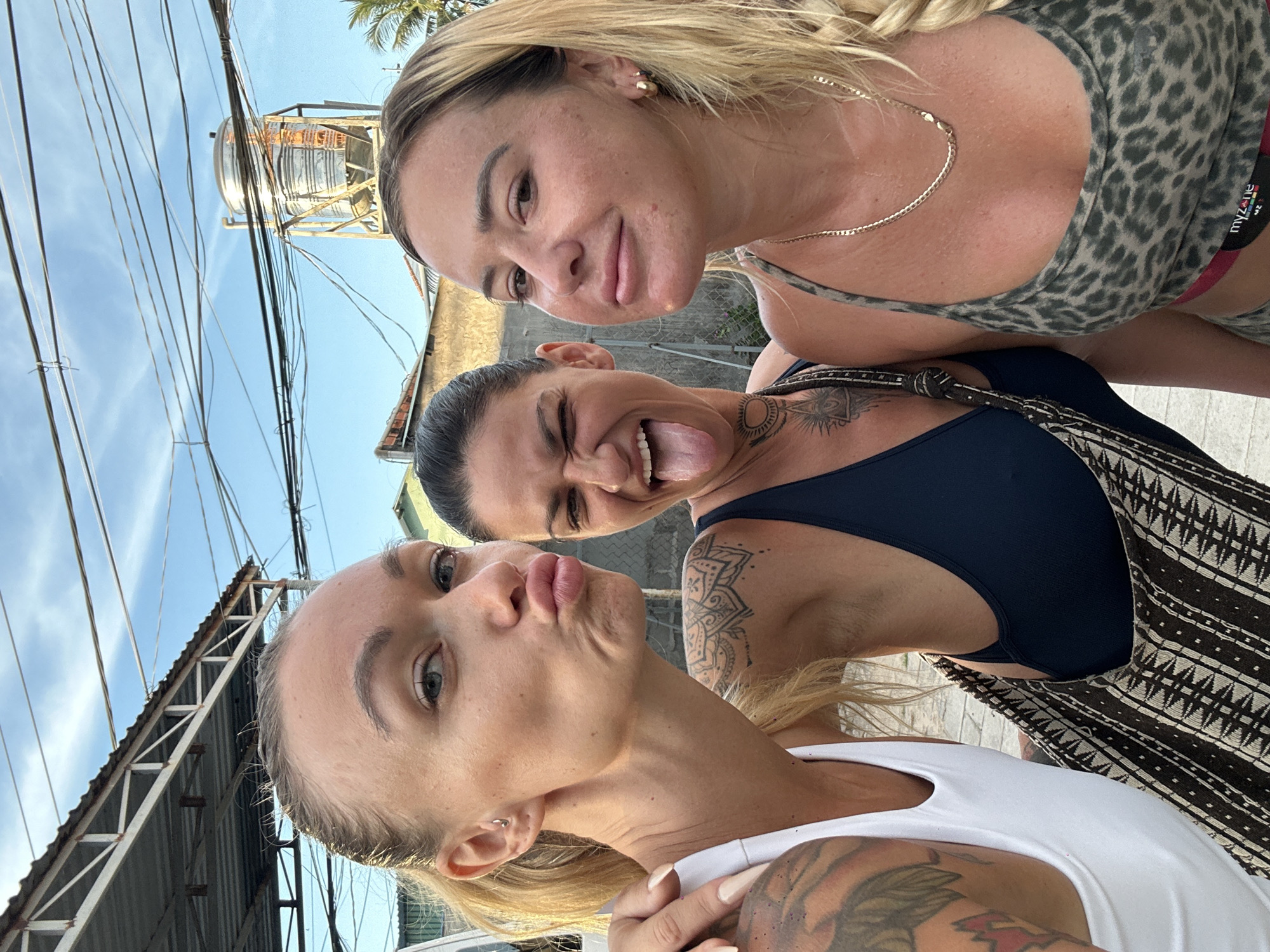 Group workout and selfies on a palm-lined courtyard in Mũi Né