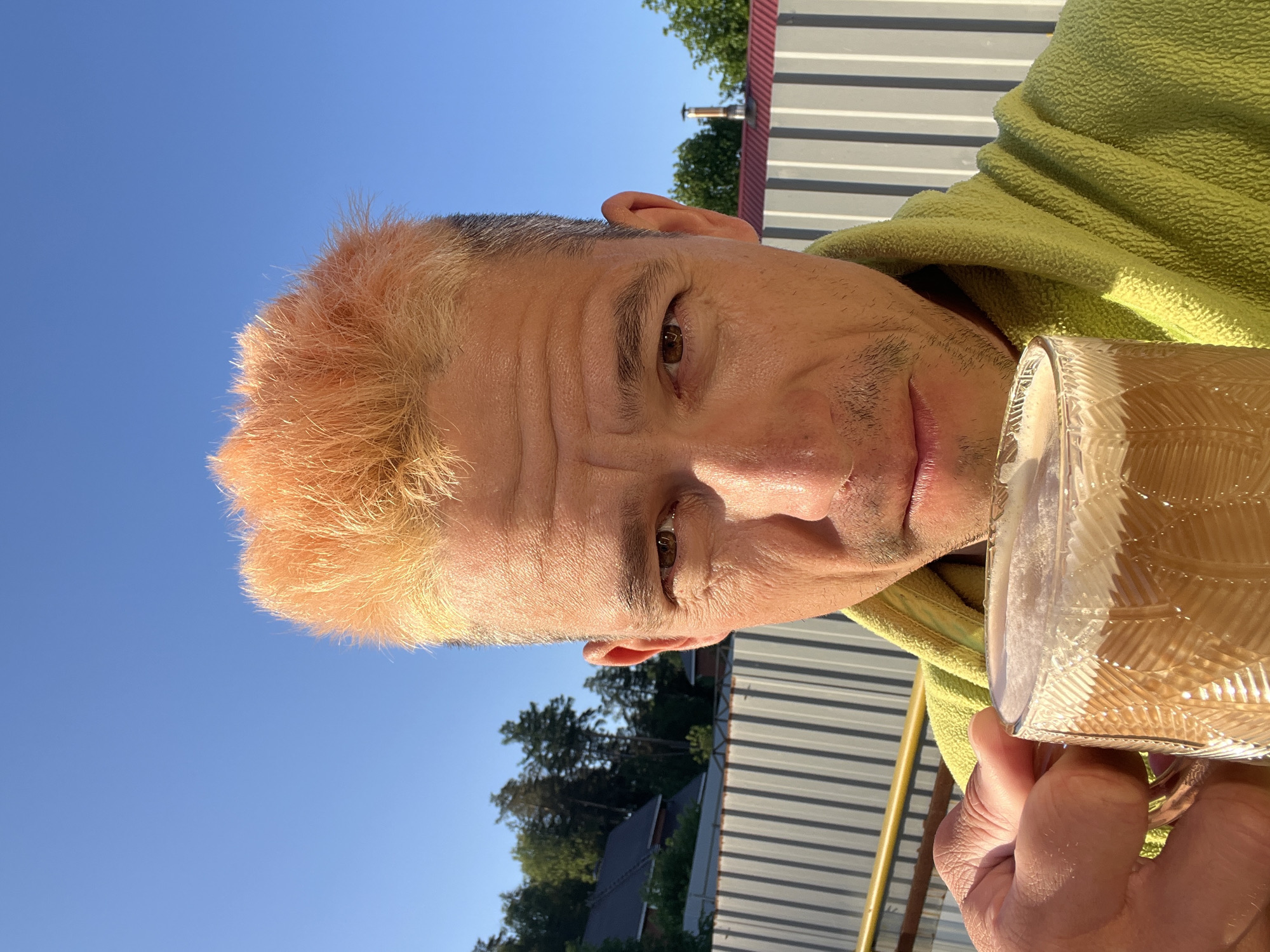 Man drinks outdoors in overgrown Chaikovsky area early morning
