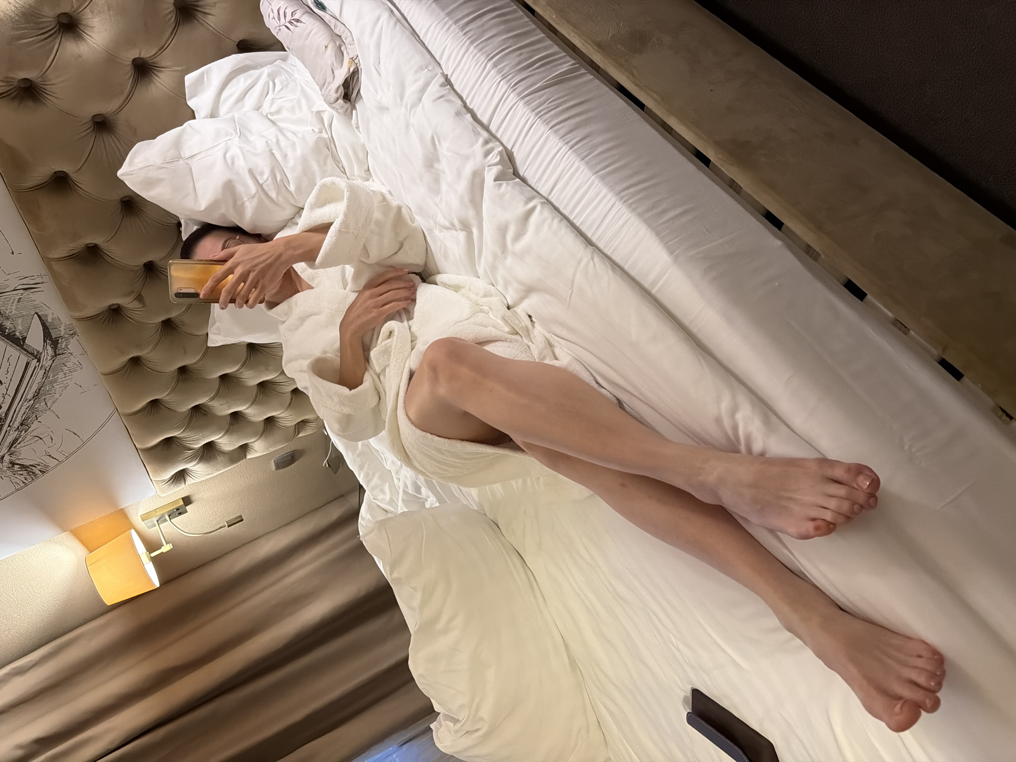 Person photographed using smartphone while resting in bed