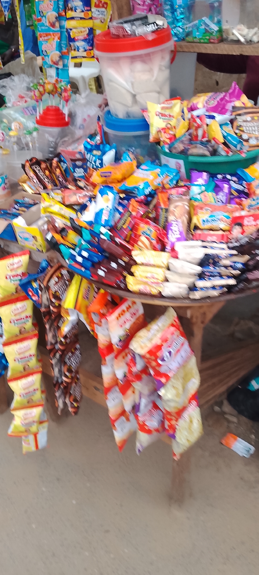 Lagos street market stalls selling snacks, onions, and yams