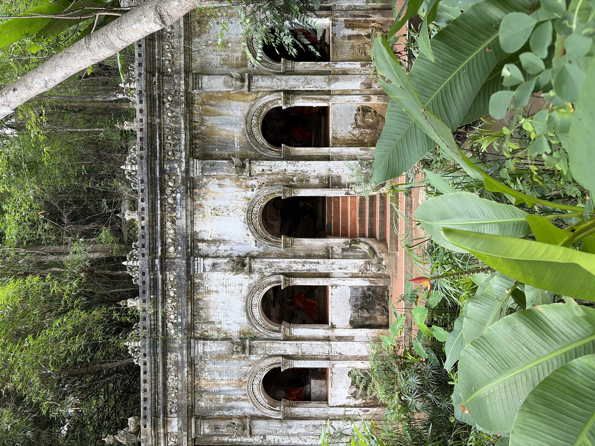 Ancient jungle-edged temple with Buddha alcoves, Suthep hillside