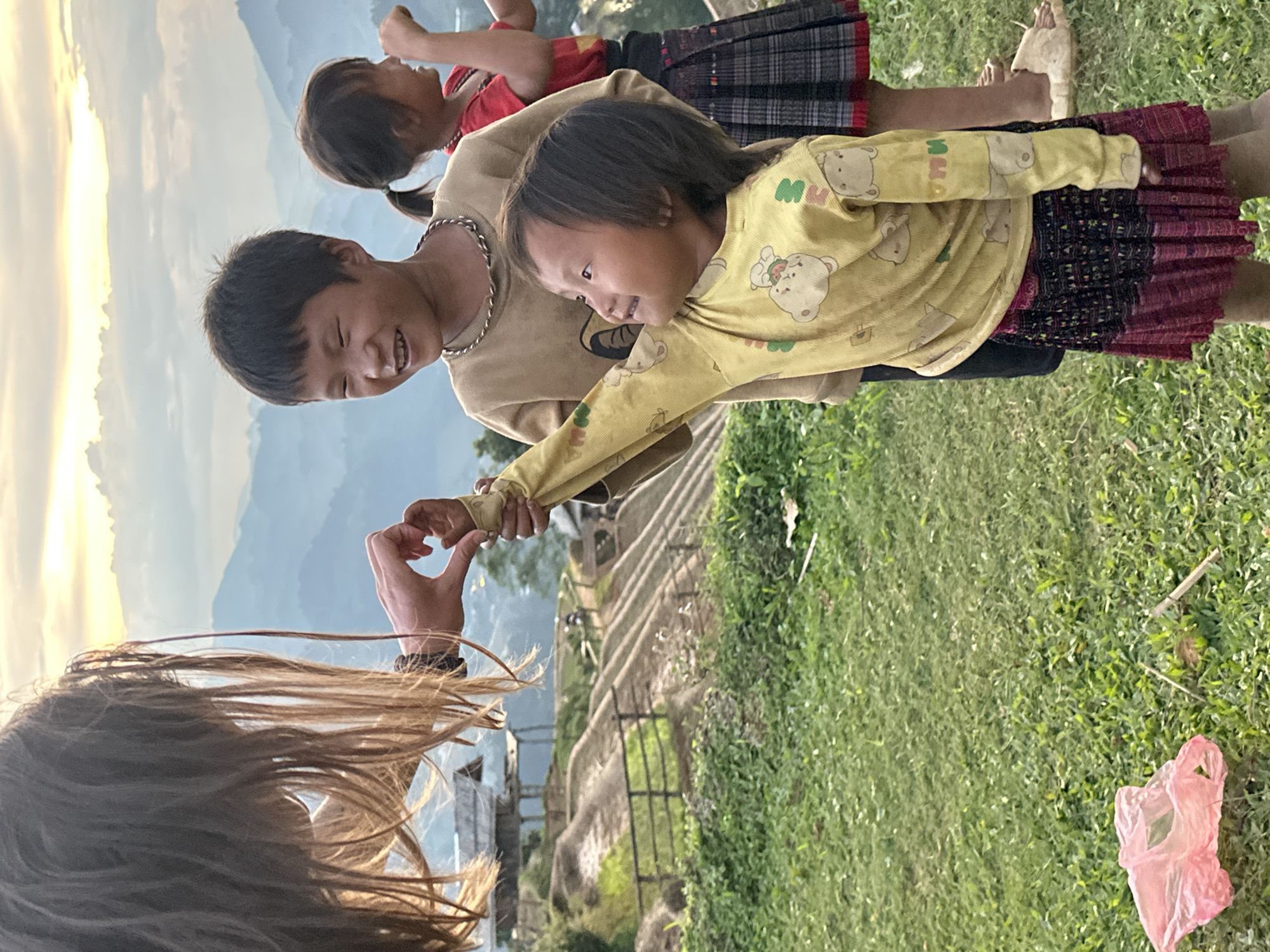 Families play among Vietnam's terraced rice fields during golden hour