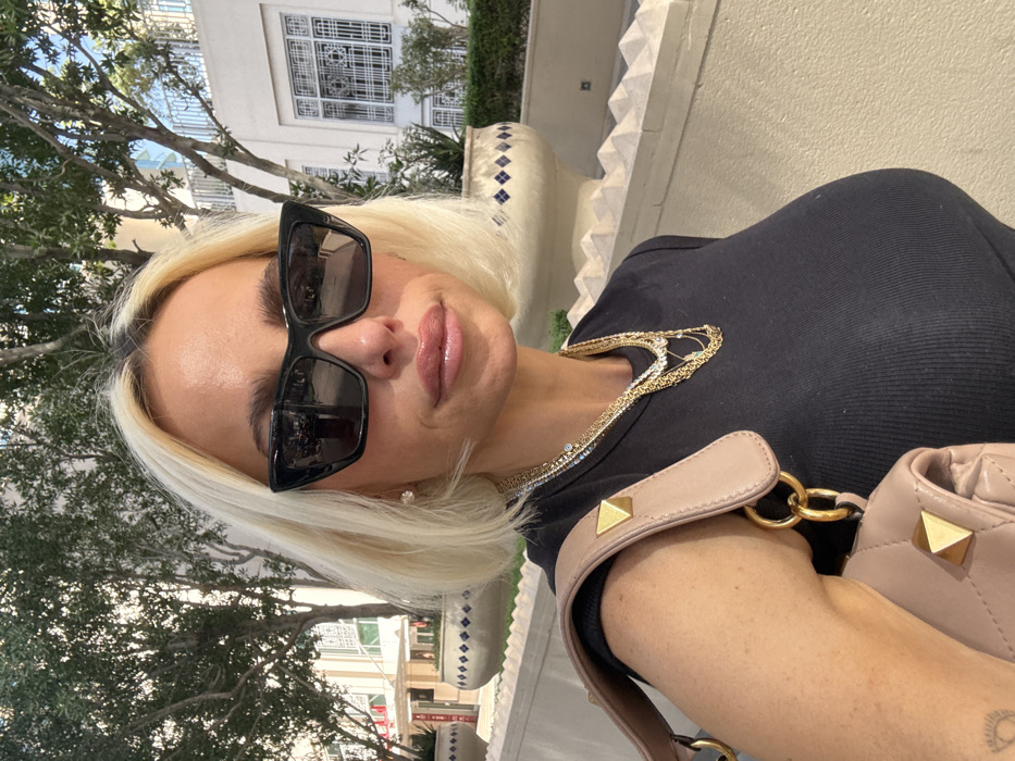 Woman takes selfie in Dubai wearing sunglasses and jewelry