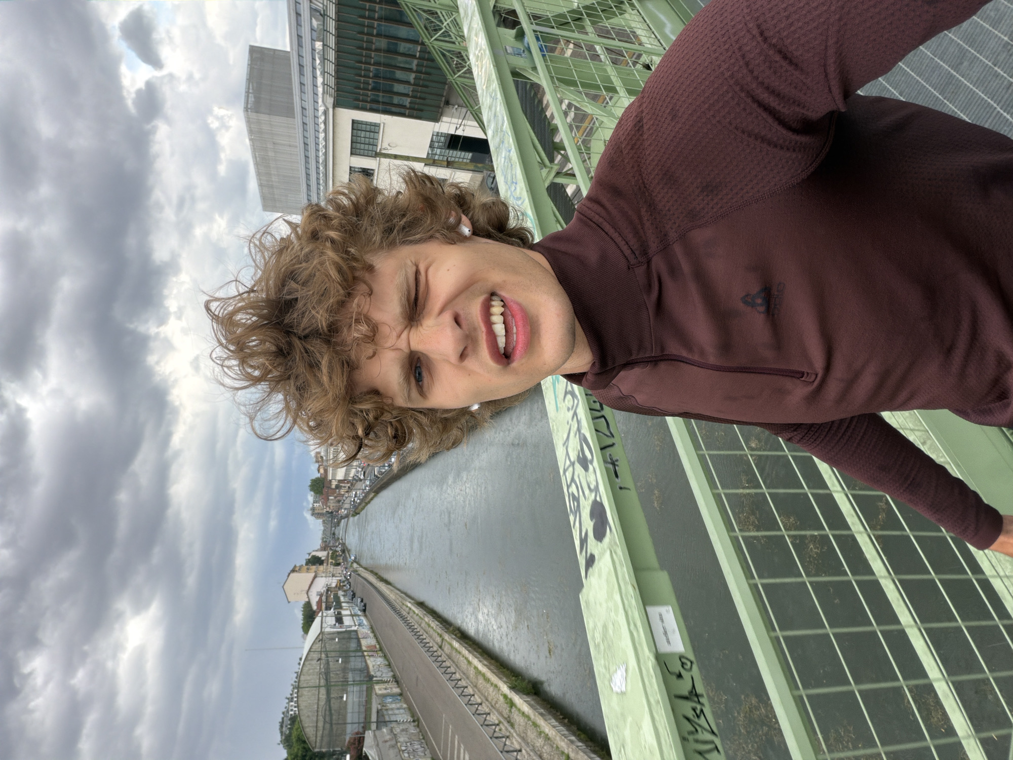 Young person takes cheerful selfie on Milan bridge